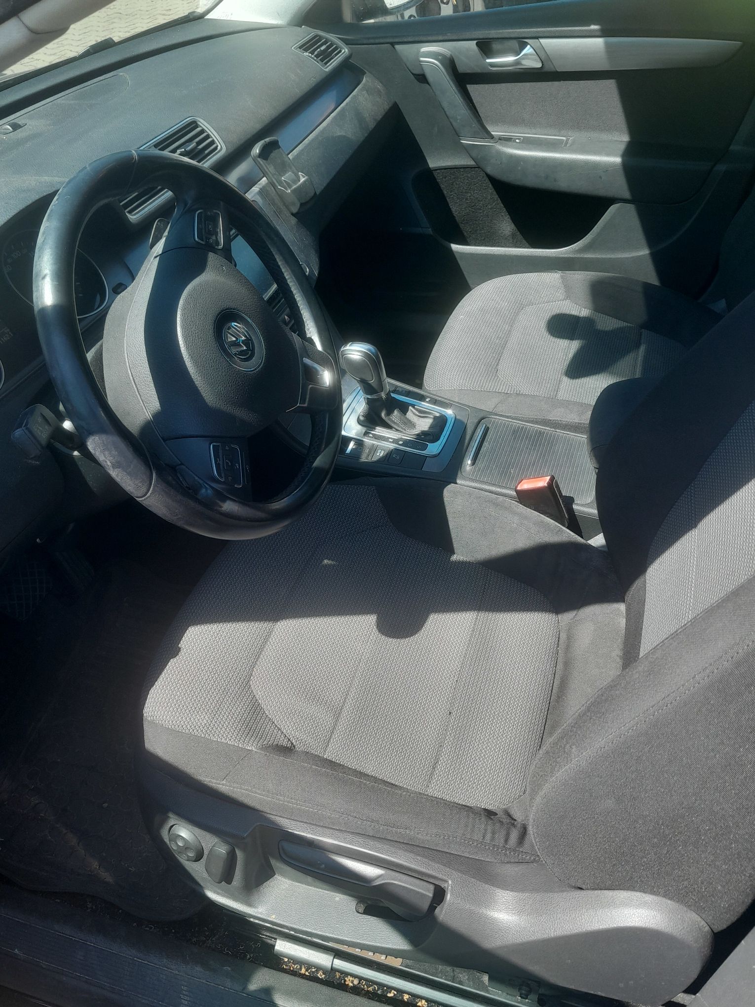 Wnętrze Volkswagena Passata, z szarymi fotelami, kierownicą i deską rozdzielczą
