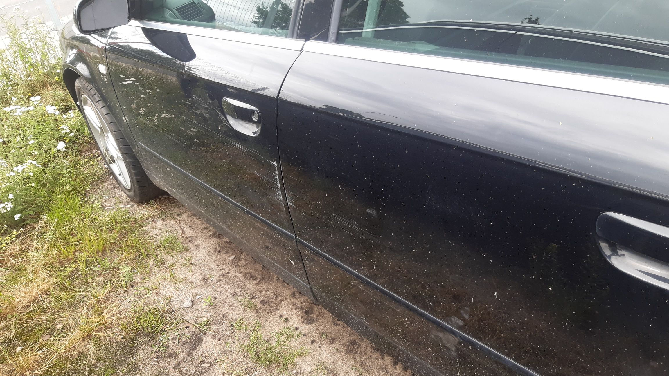 Czarny samochód Audi A4 Avant w wersji kombi, widok z boku