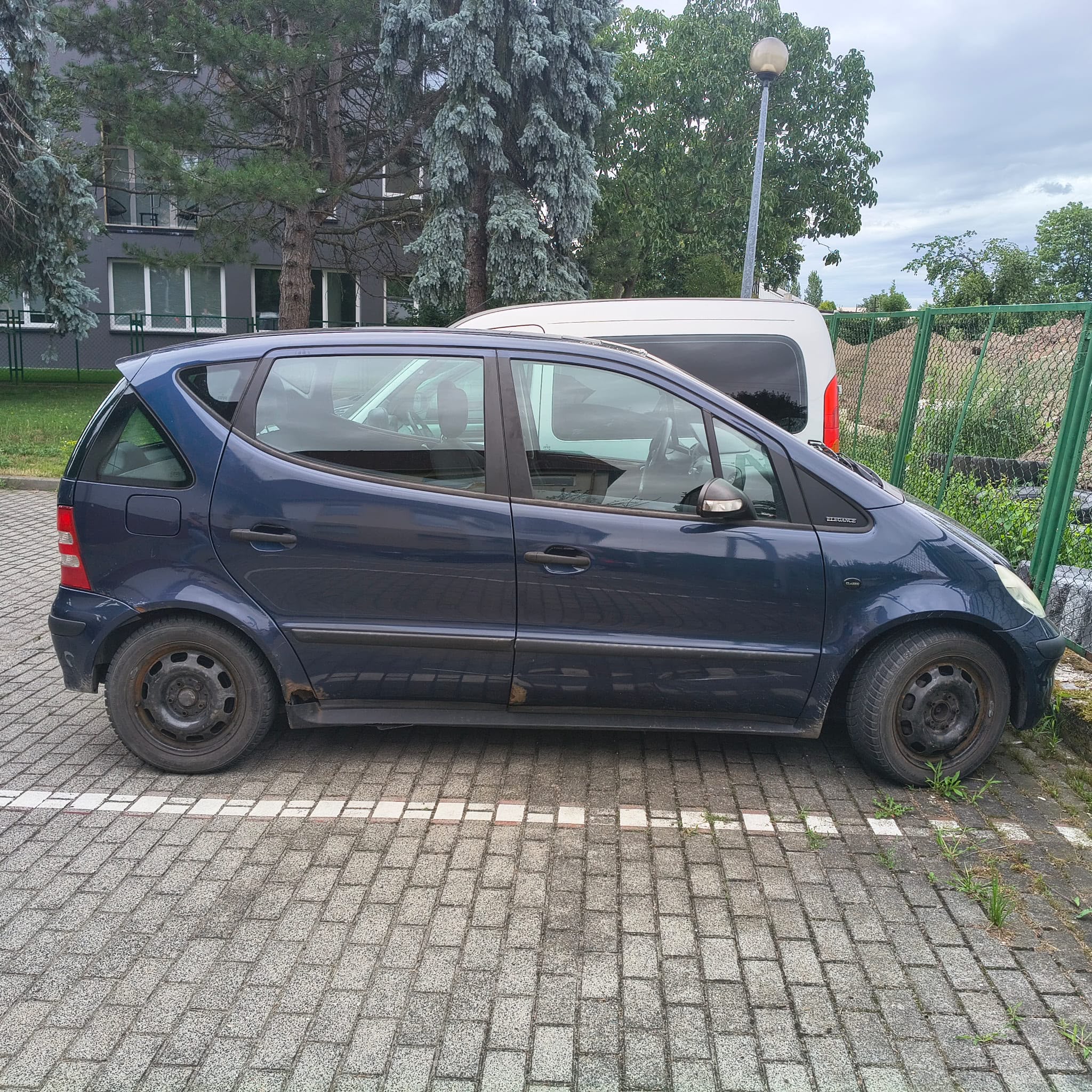 Mercedes-Benz w kolorze granatowym, widok z boku.