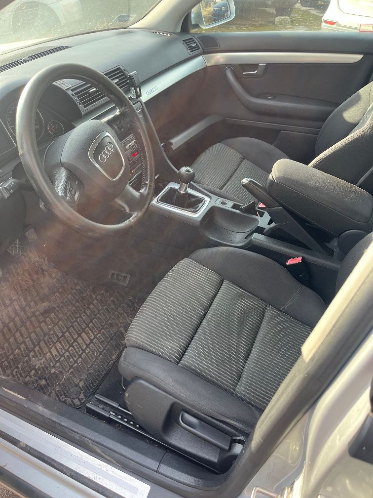 Wnętrze samochodu Audi A4 B7, widok na przednie fotele, kierownicę i deskę rozdzielczą.