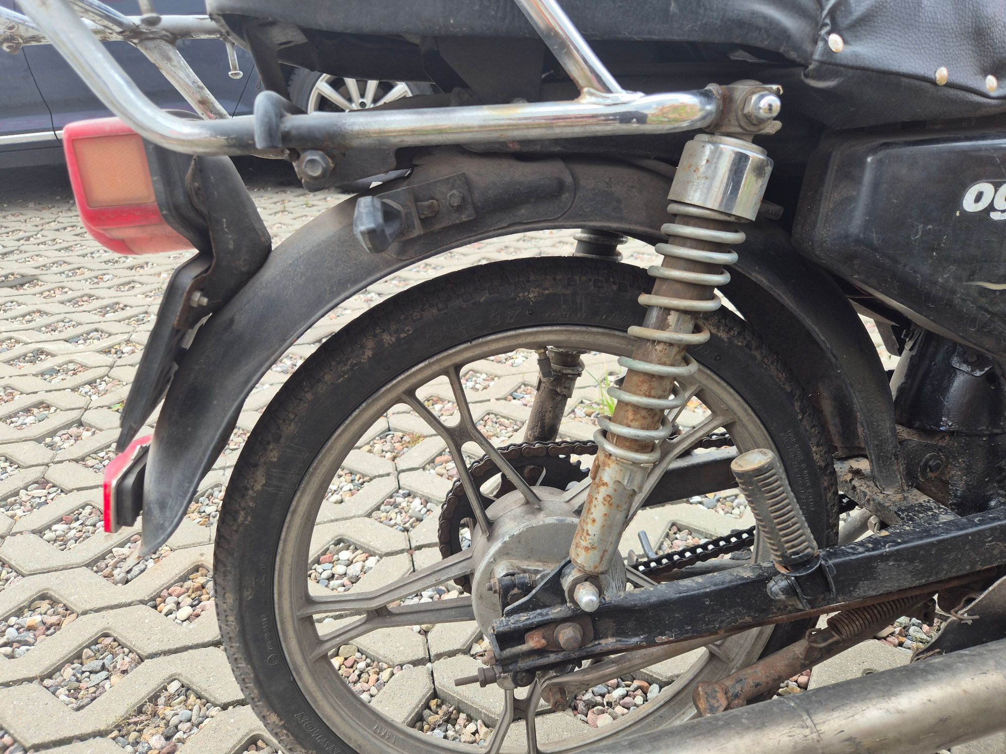 Tylne koło motoroweru. Widoczny naloty rdzy na tylnym amortyzatorze.