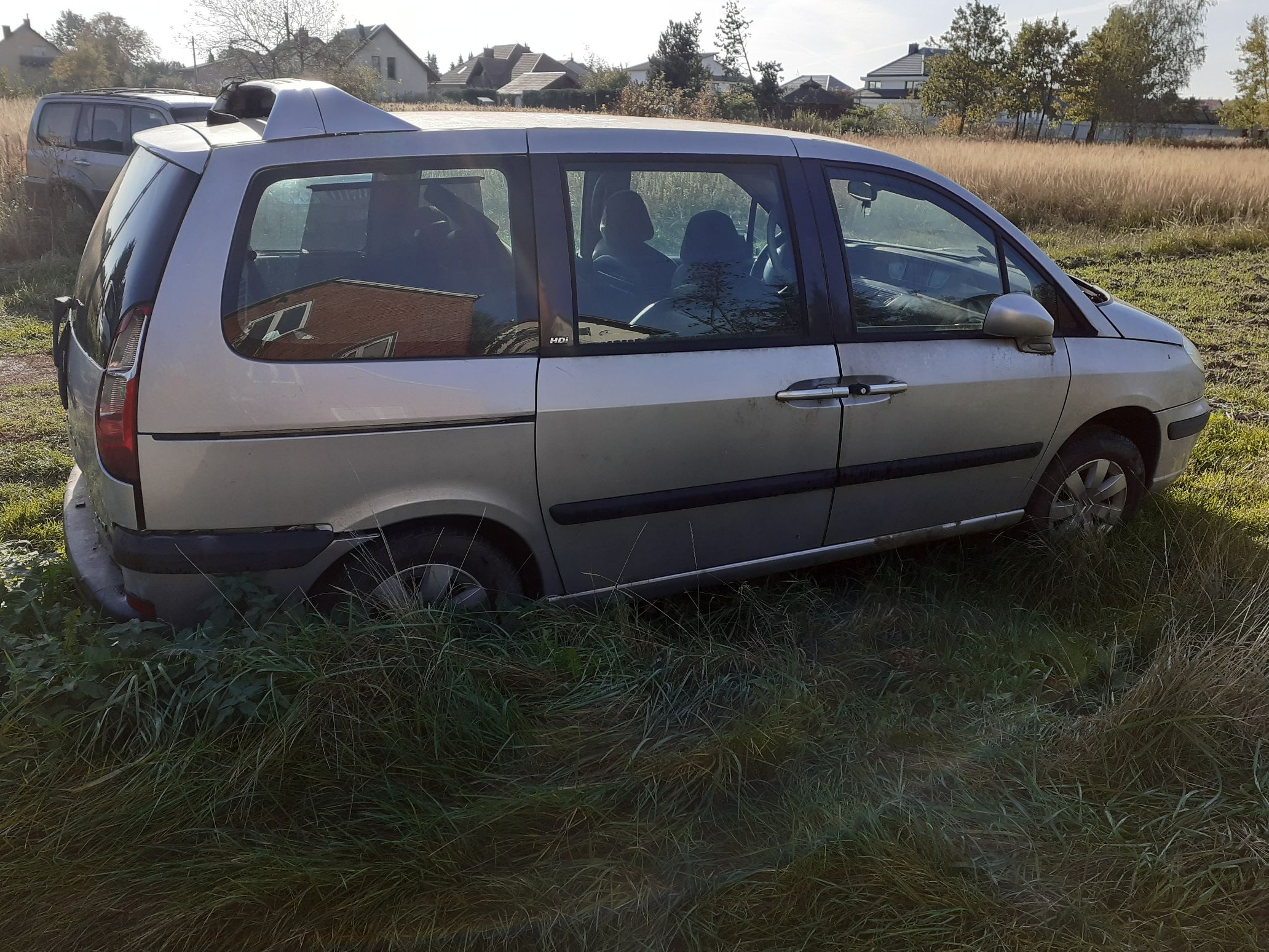 Srebrny samochód osobowy Peugeot typu minivan widoczny z boku ze śladami korozji na progu.