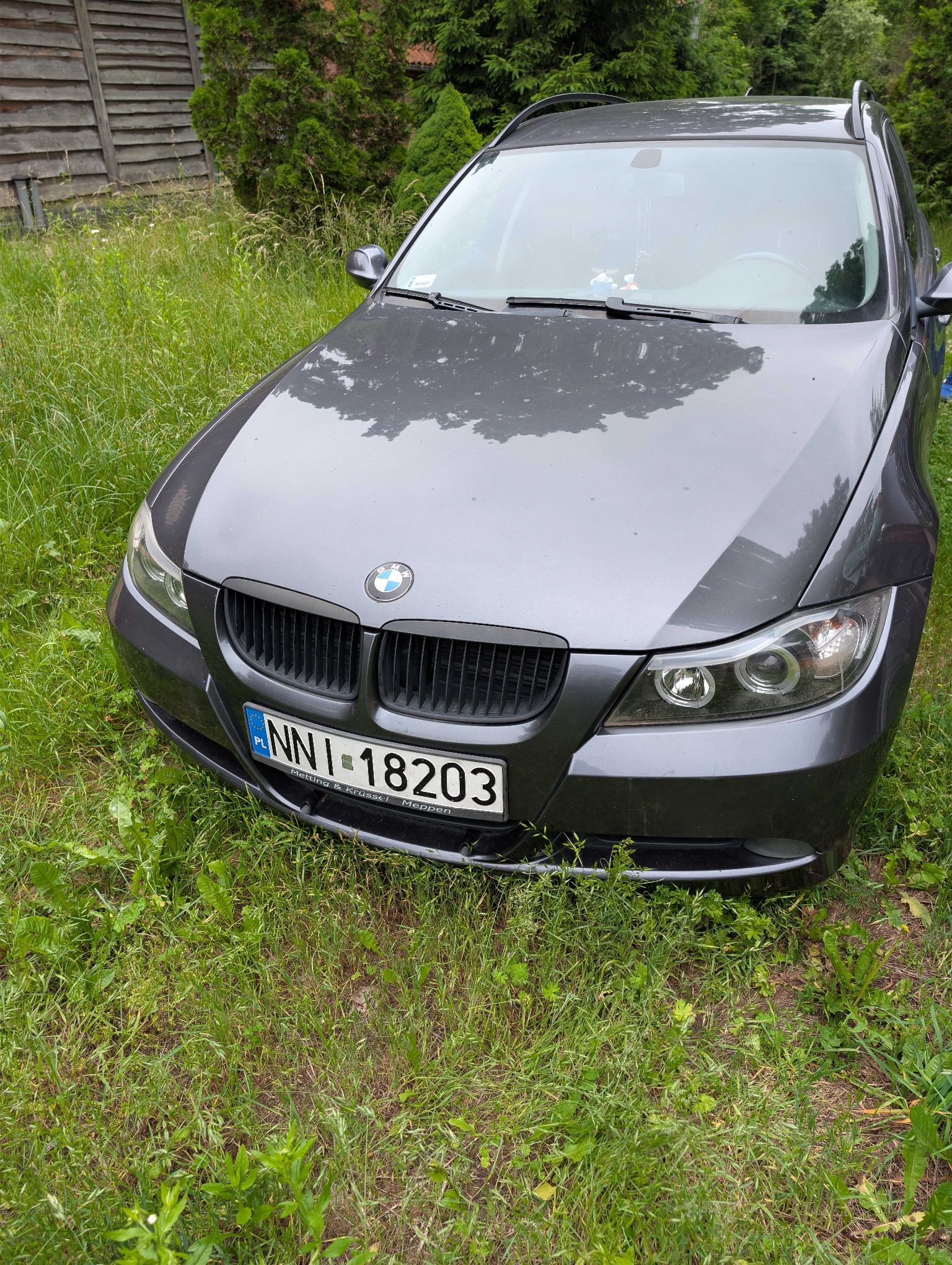 Ciemnoszare kombi BMW. Samochód jest sfotografowany z przodu.