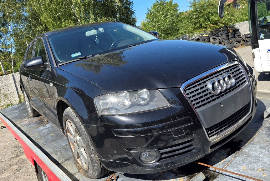 Granatowy samochód Audi A3. Widok od przodu z widocznym logo marki na grillu.