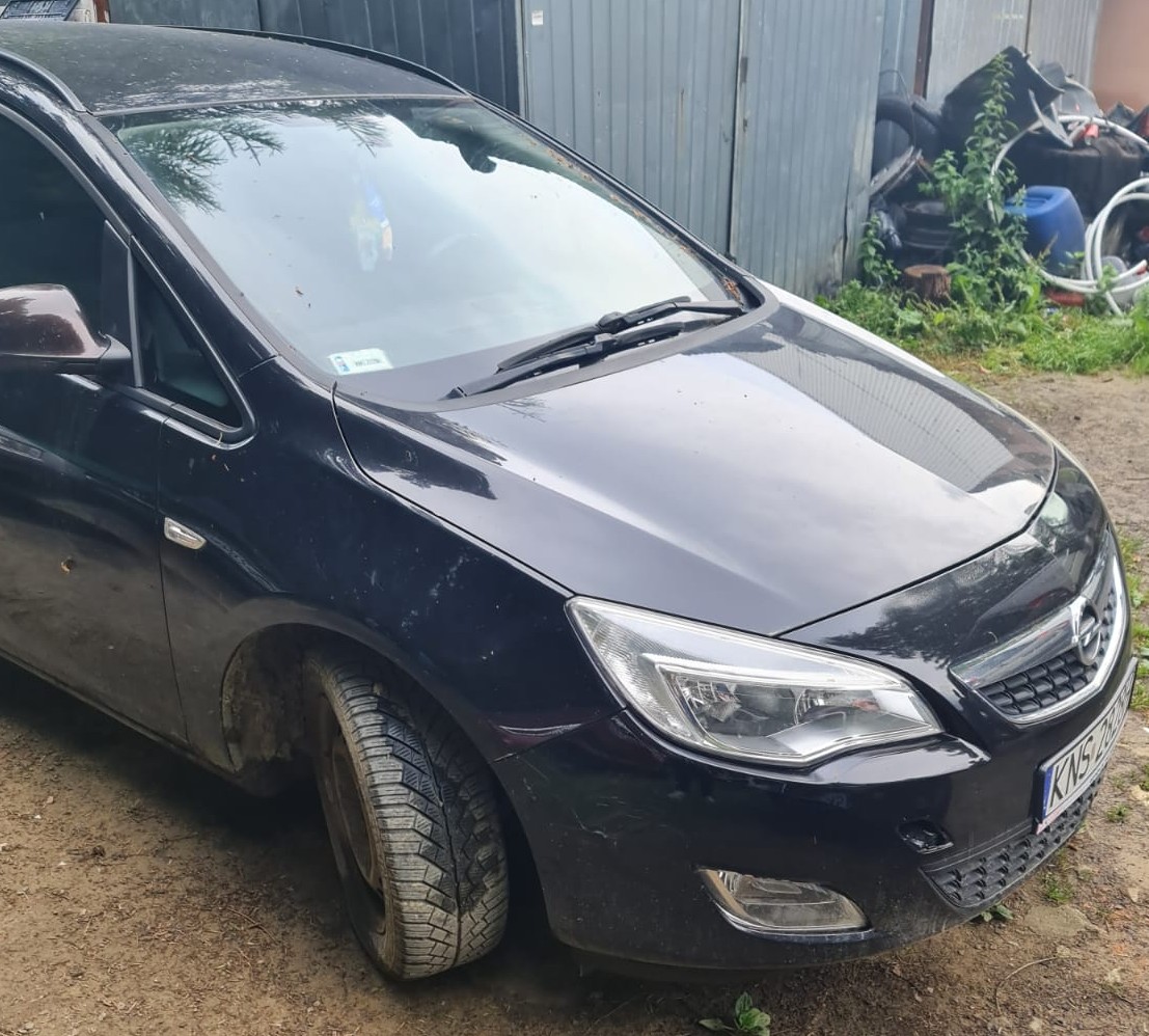 Prawy bok granatowego pojazdu marki Opel Astra.