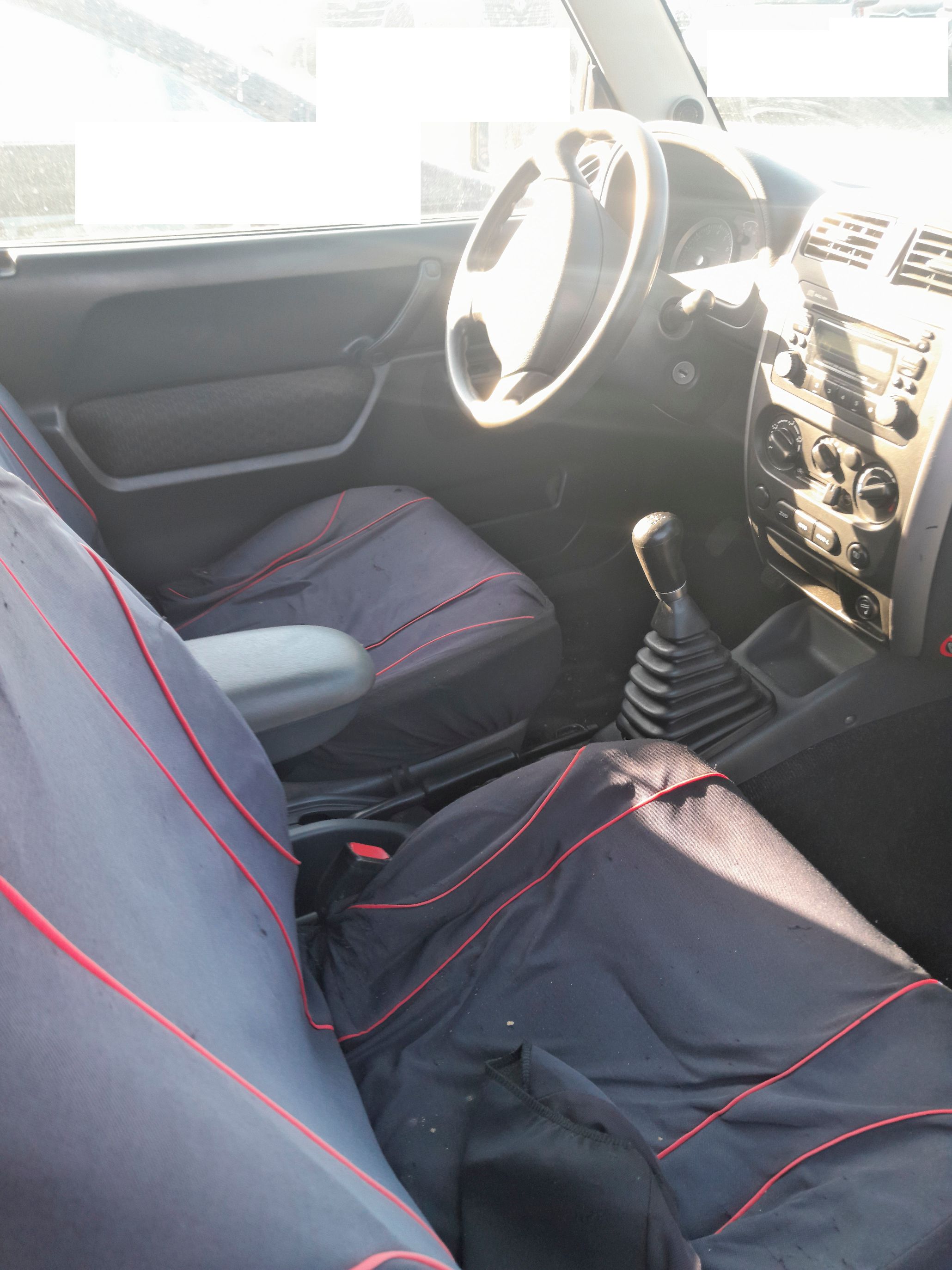 Wnętrze Suzuki Jimny z szarymi fotelami kierownicą i pulpitem