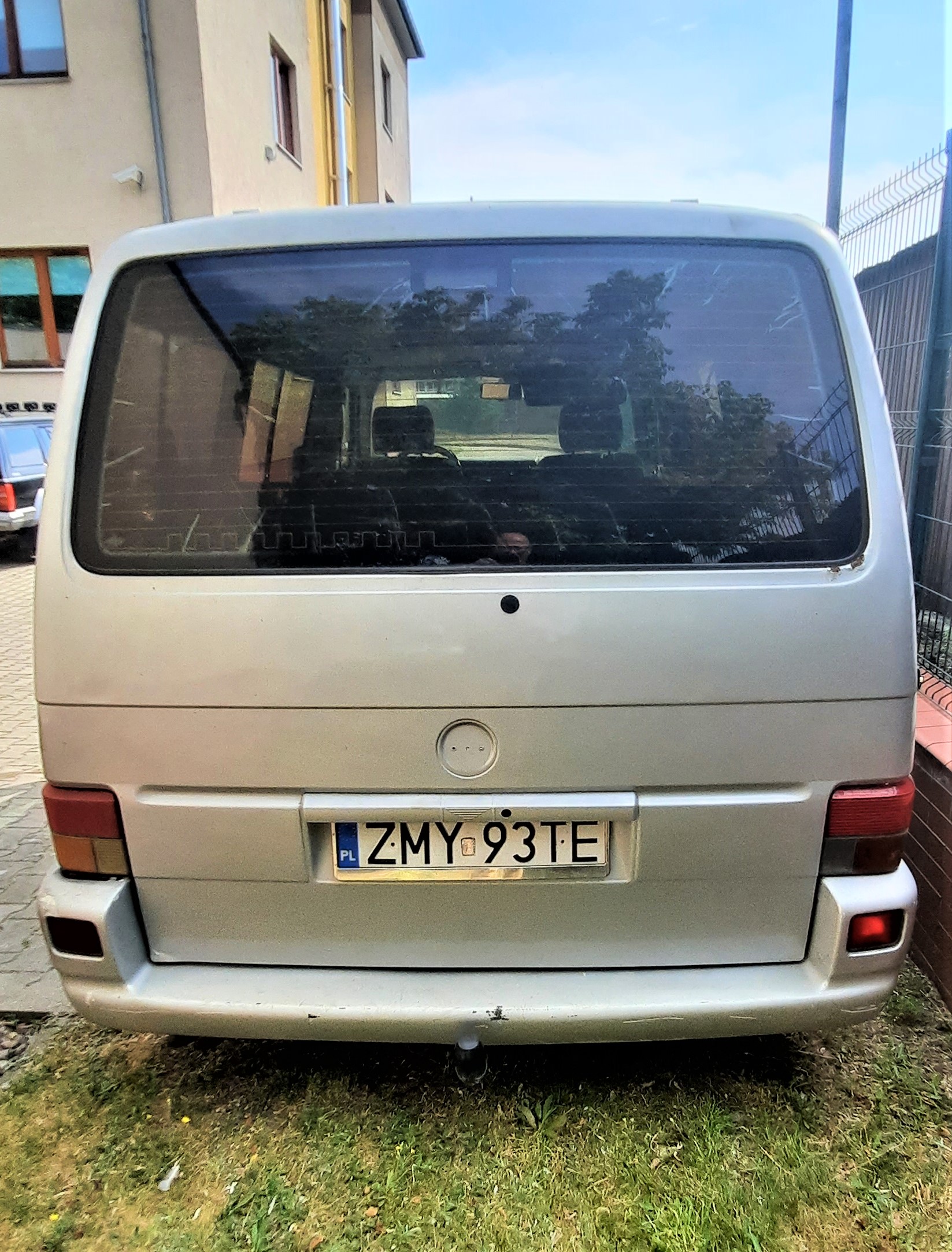 Tył pojazdu, ślady korozji na klapie, brak wycieraczki szyby, brak loga pojazdu, hak holowniczy, zarysowania na zderzaku