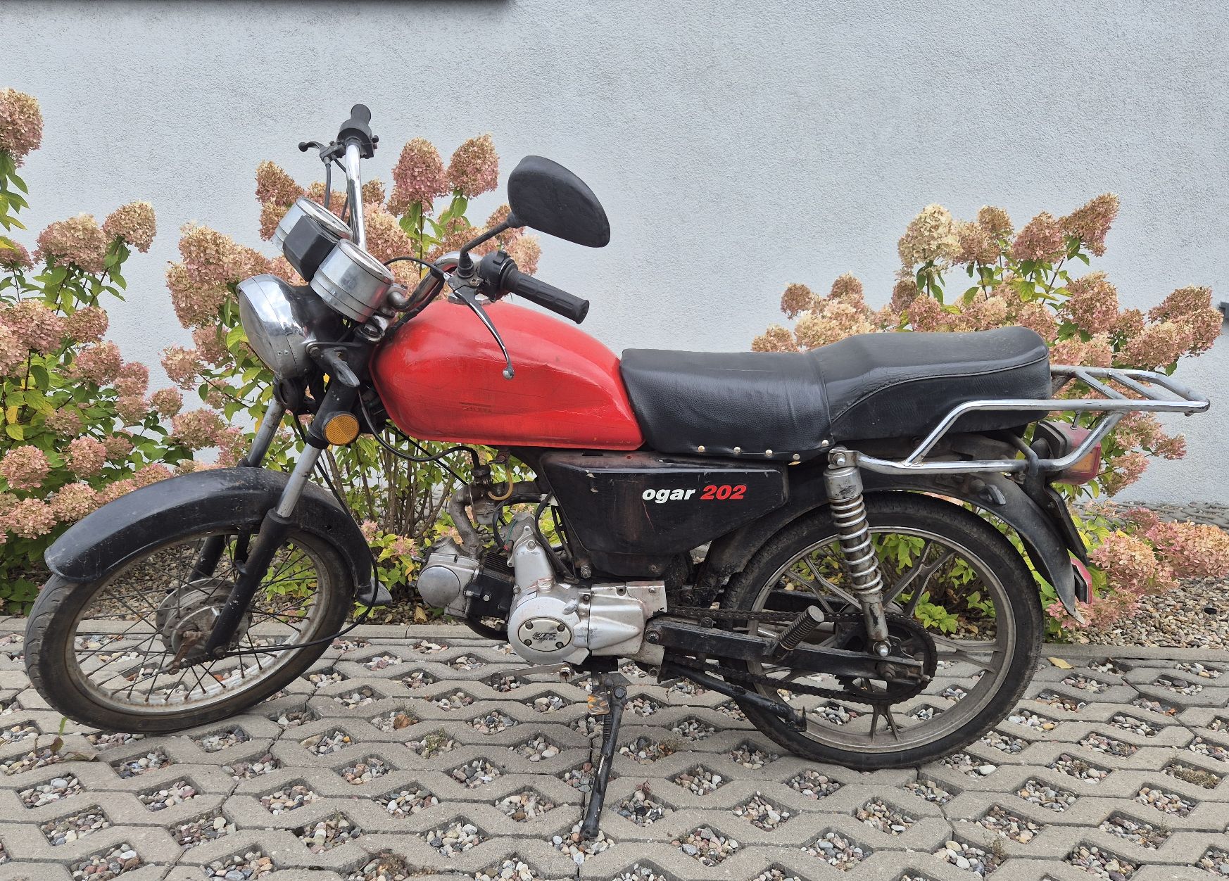 Widok motoroweru z lewej strony. Widoczne ślady naprawy obicia siedziska i zużycia lakieru.
