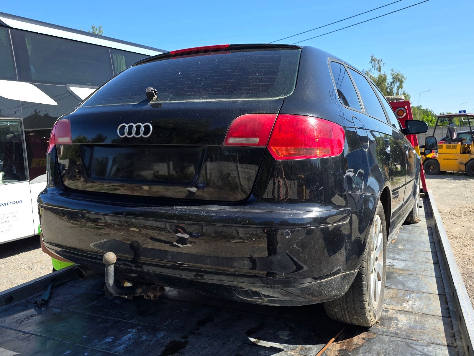 Granatowy samochód Audi A3. Widok z tyłu z widocznym hakiem oraz logo marki.