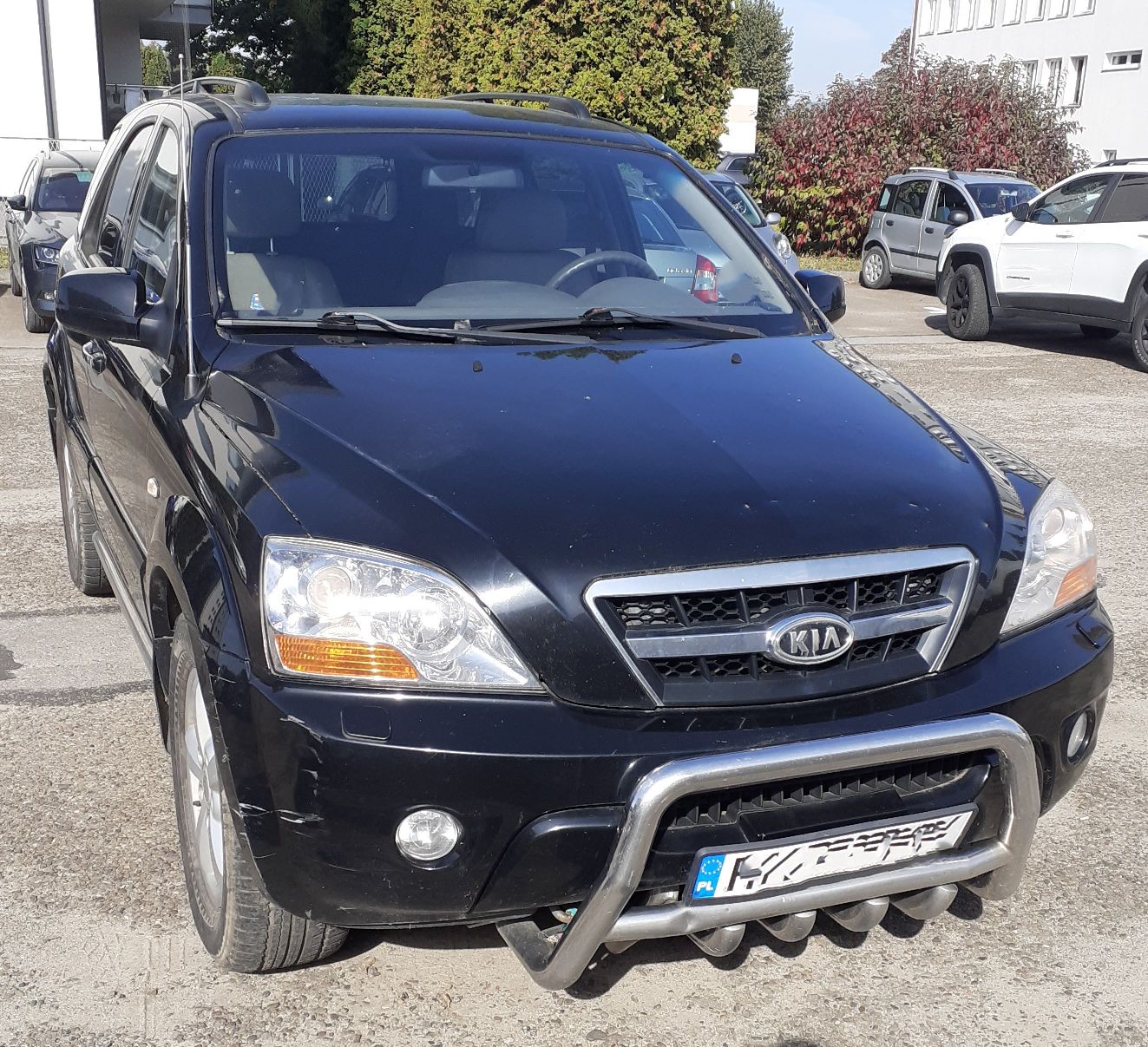 Czarny SUV Kia Sorento z srebrnym orurowaniem z przodu.