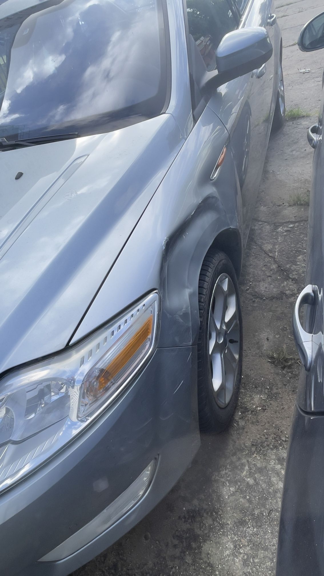 Uszkodzenia lewy błotnik samochodu Ford Mondeo