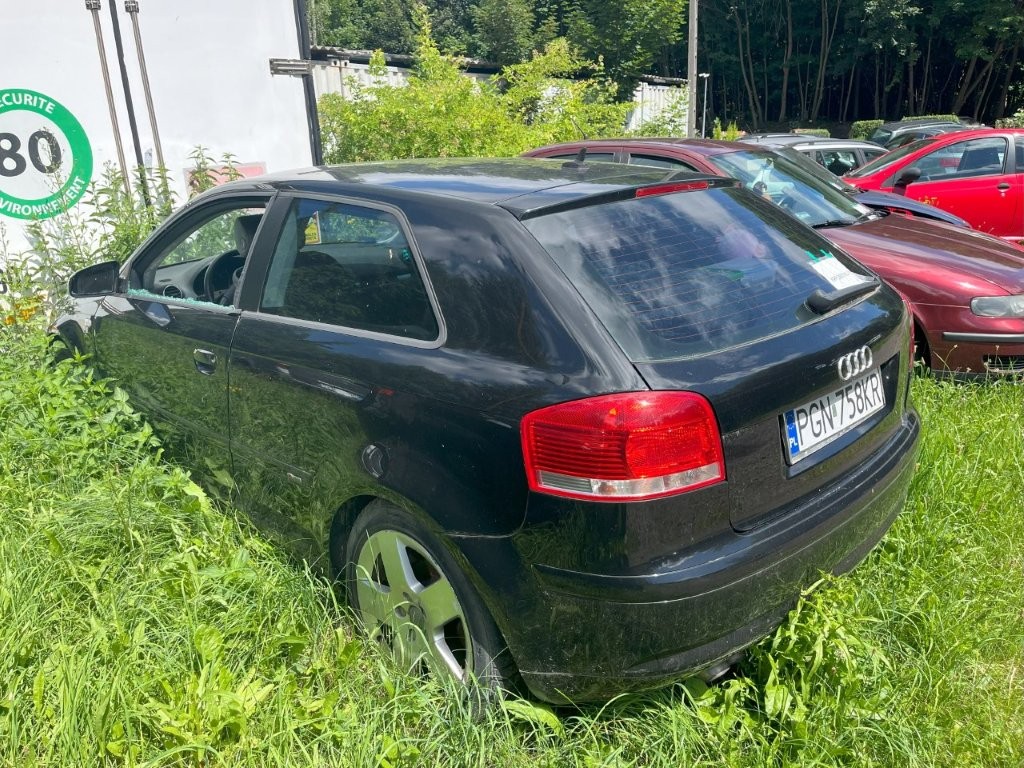 Tył i lewy bok pojazdu z widocznymi zarysowaniami i stłuczoną szybą w lewych przednich drzwiach