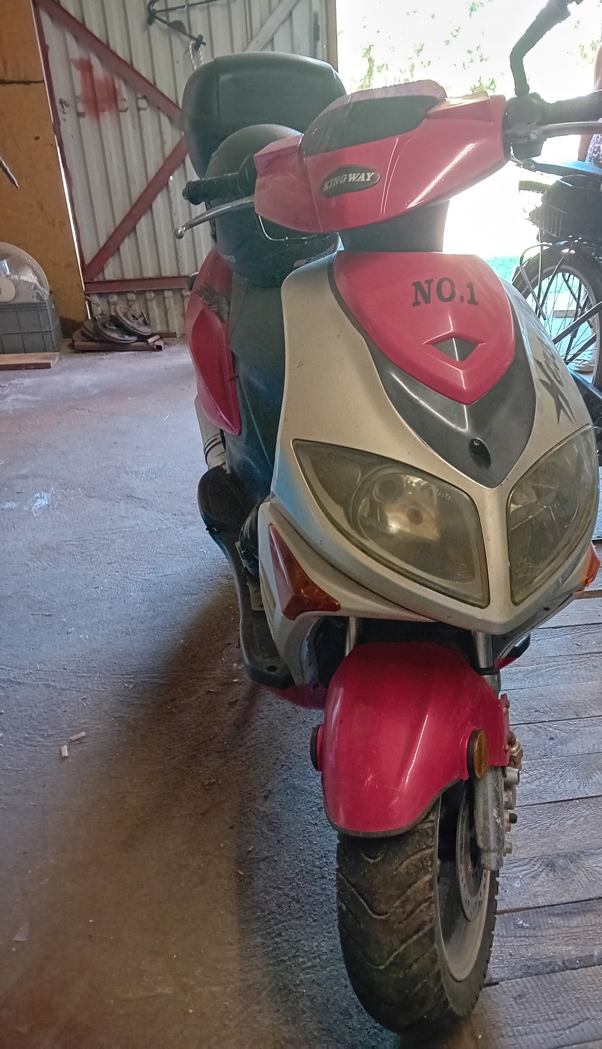 Przód motoroweru przedstawiający przednie lampy, błotnik i koło
