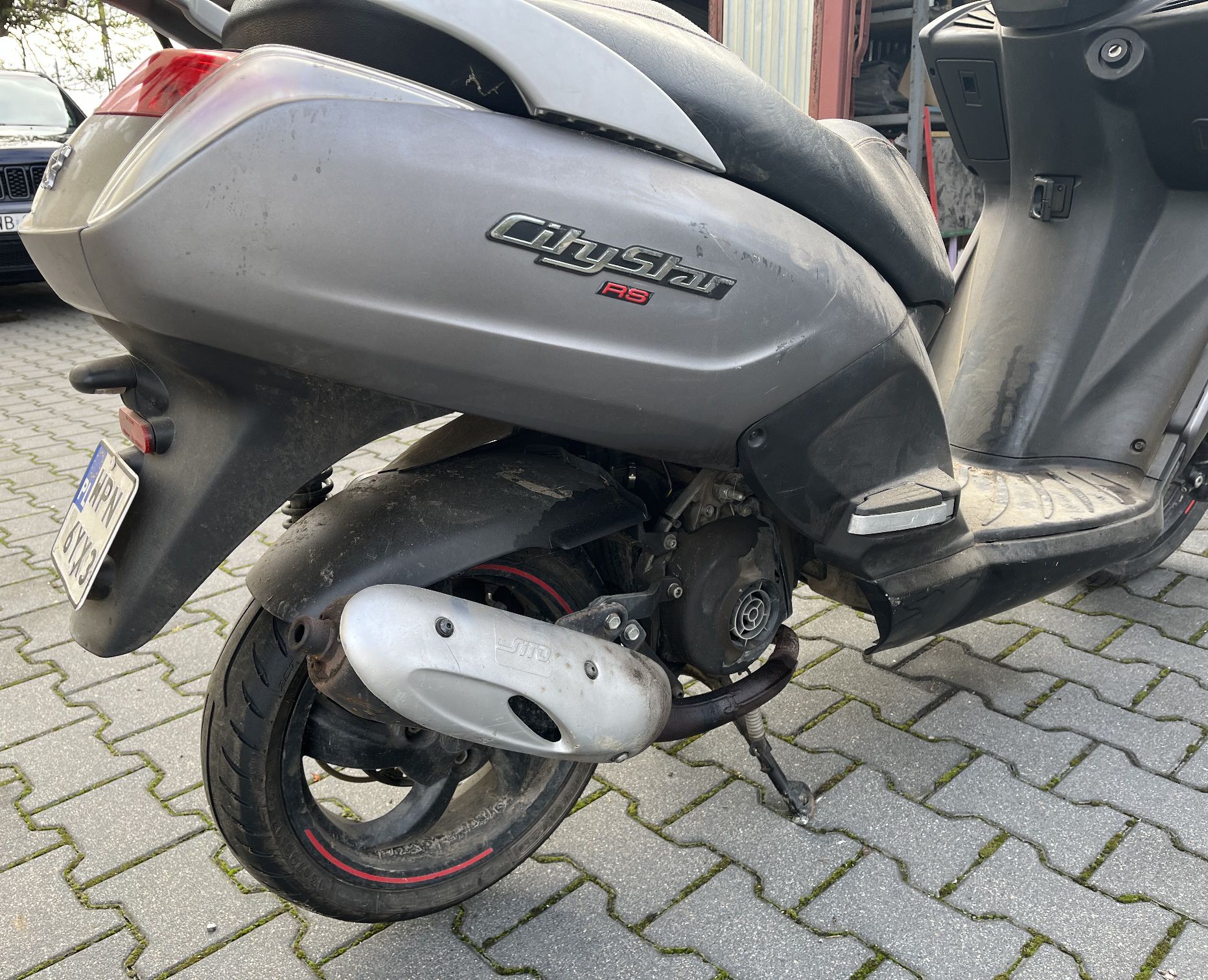 Układ wydechowy skorodowany, widoczny wyciek oleju z silnika.