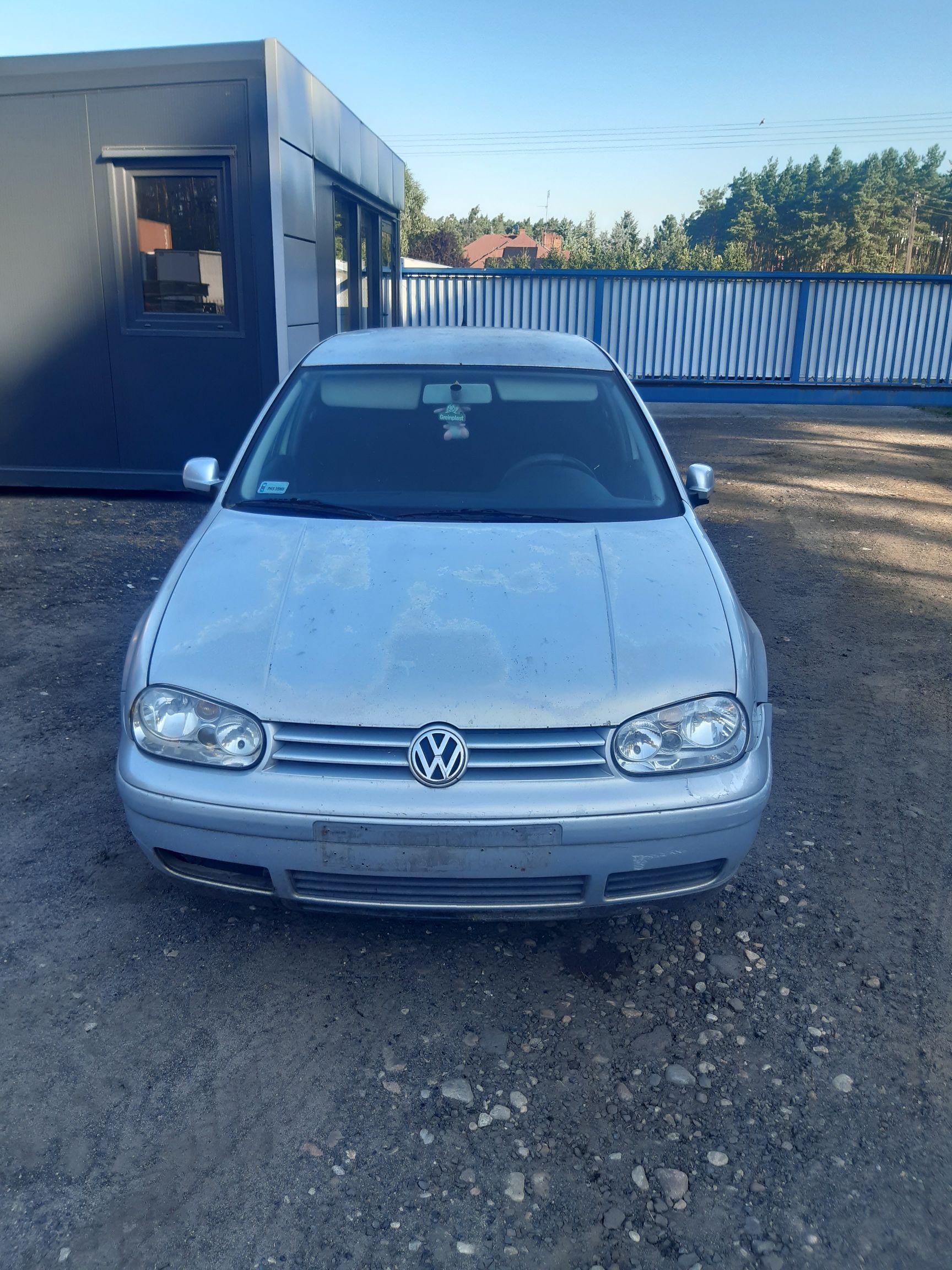 Srebrny samochód marki Volkswagen Golf IV. Pojazd ma widoczne ślady zużycia i łuszczącego się lakieru na masce oraz dachu.
