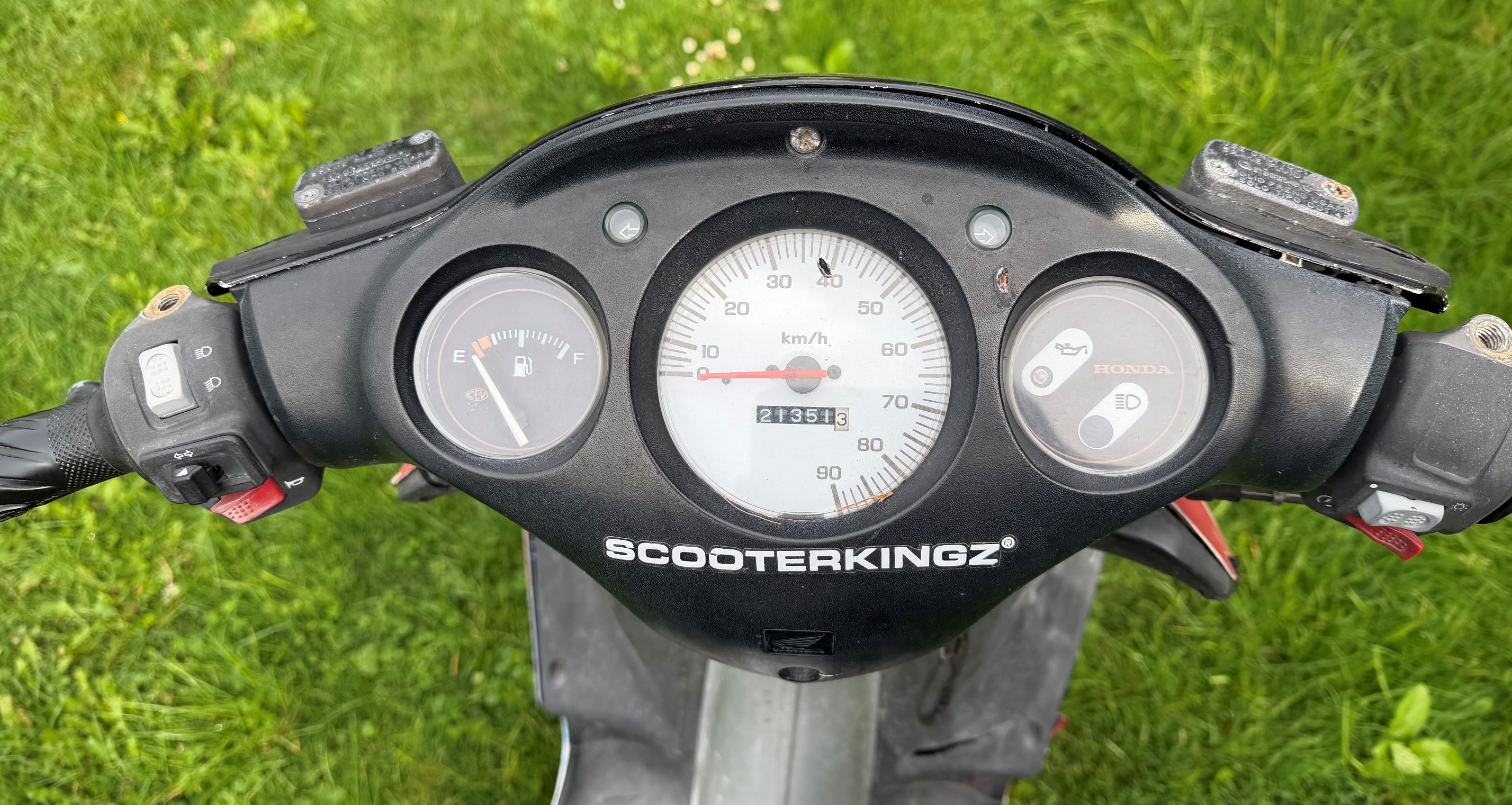 Widok liczników na kierownicy motoroweru.