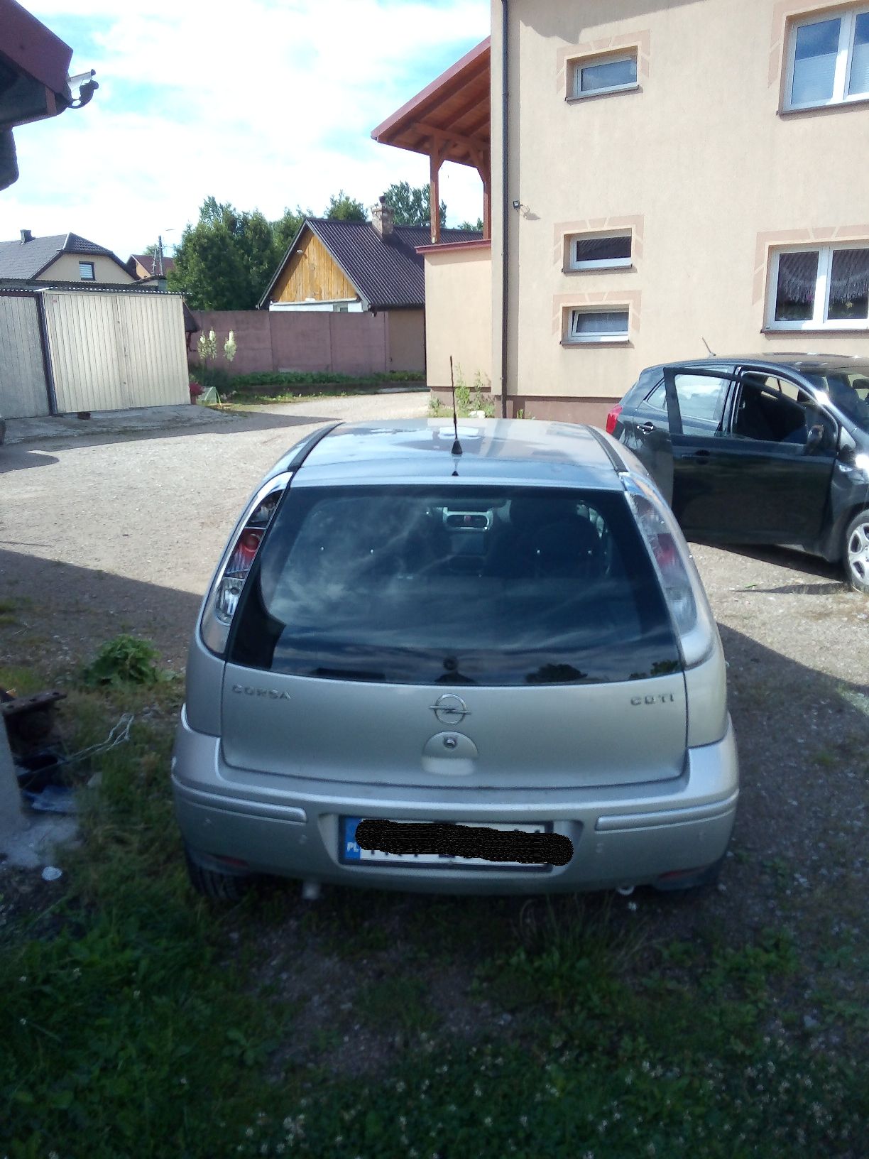 Srebrny samochód osobowy marki Opel Corsa widziany z tyłu