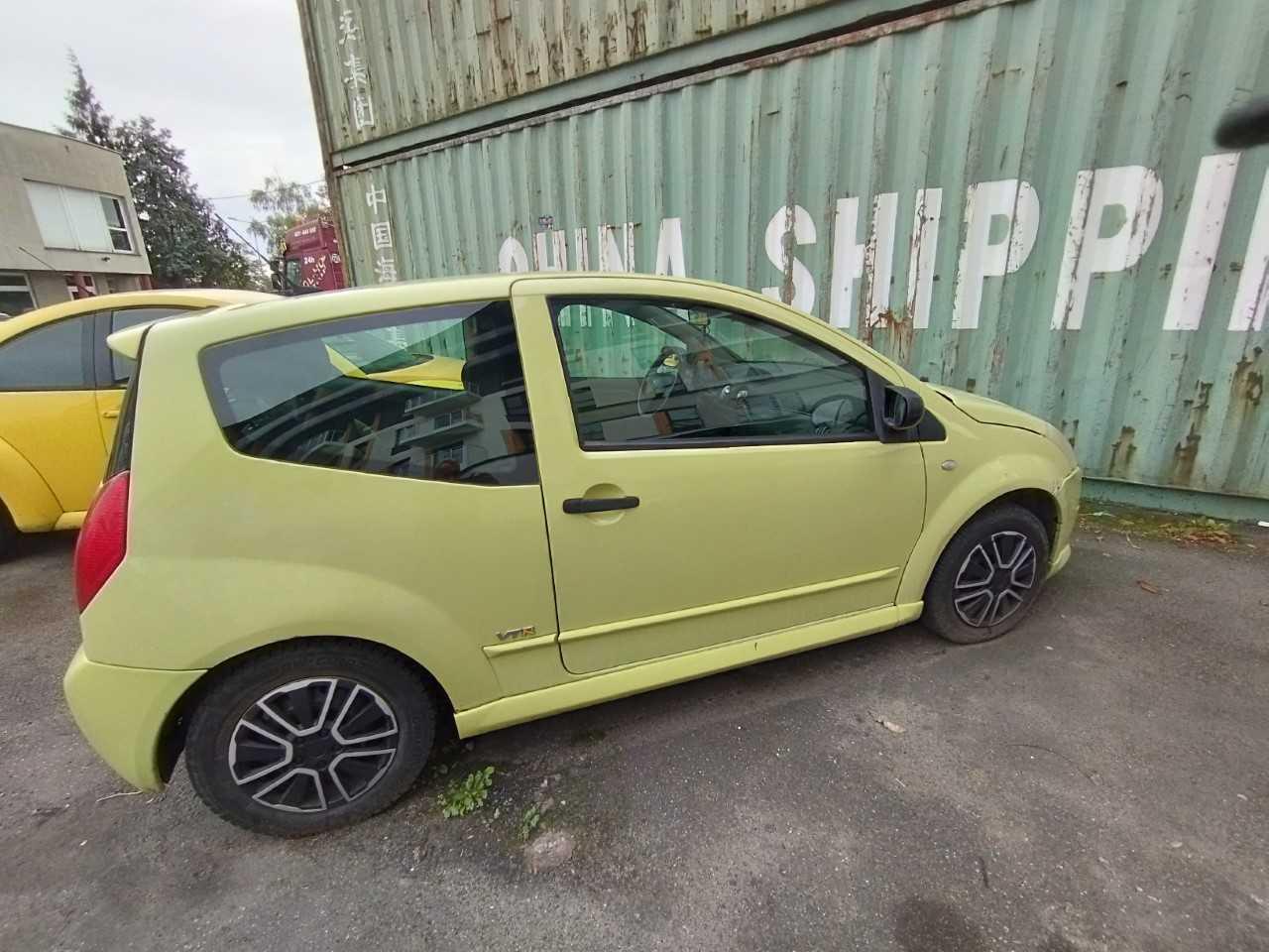 Trzydrzwiowy Citroën C2, pojazd w kolorze limonkowym, prawa strona bez widocznych uszkodzeń.