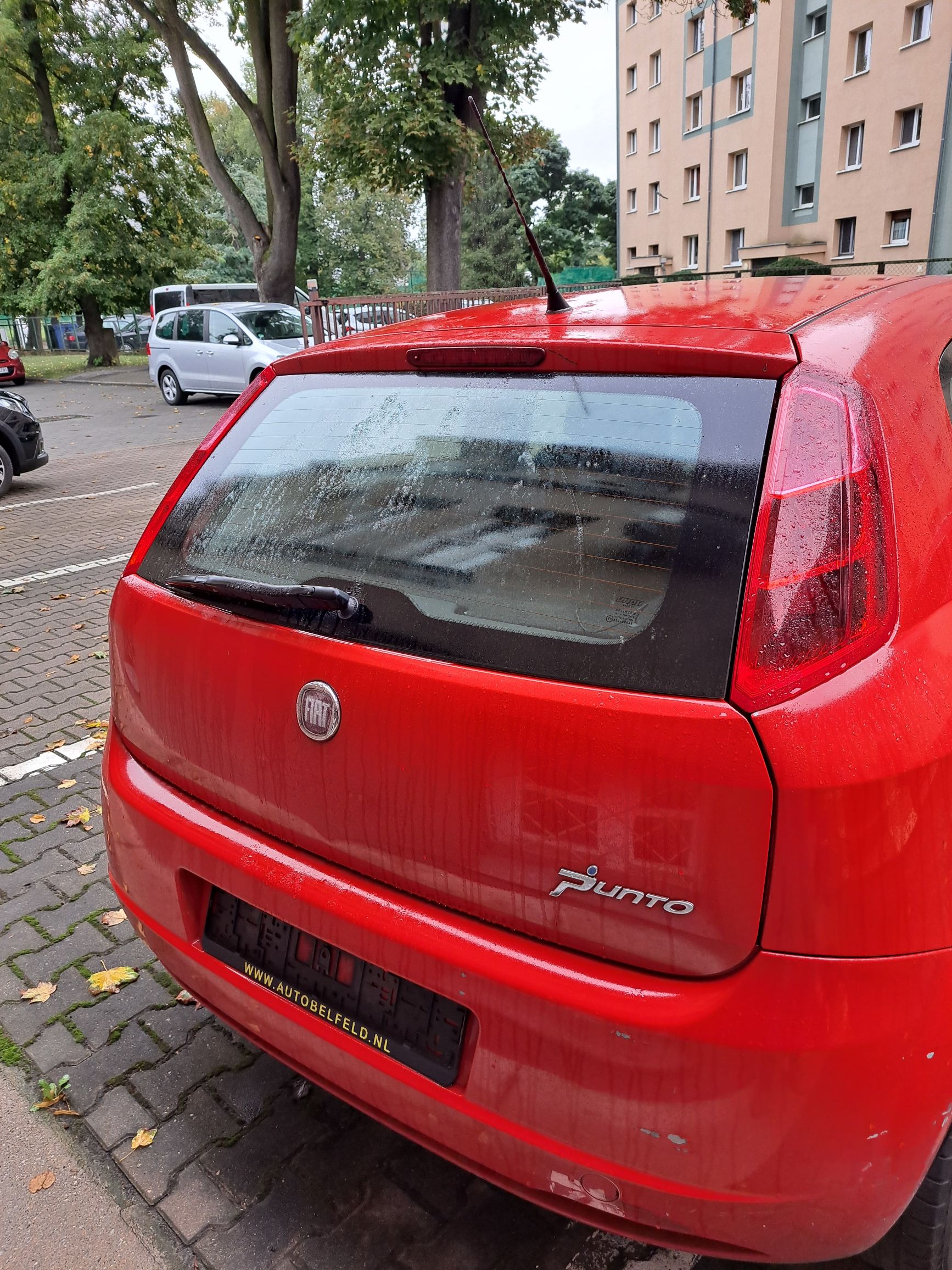 tył czerwonego samochodu osobowego Fiata Punto zderzak lekko zarysowany