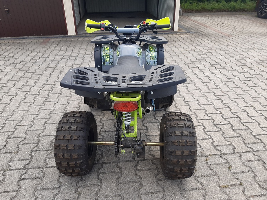 dziecięcy quad spalinowy z jaskrawozielonymi elementami ramy. Widok z tyłu