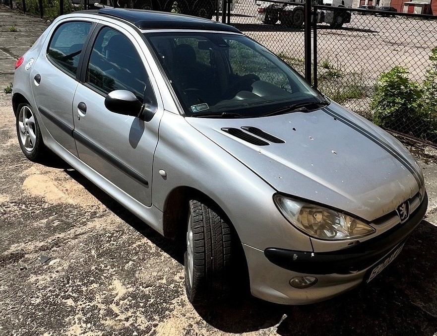 Przód srebrnego samochodu osobowego marki Peugeot z prawego boku