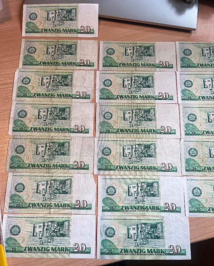 Odwrotna strona osiemnastu banknotów o nominale 20 marek NRD z motywem dzieci w szkole.