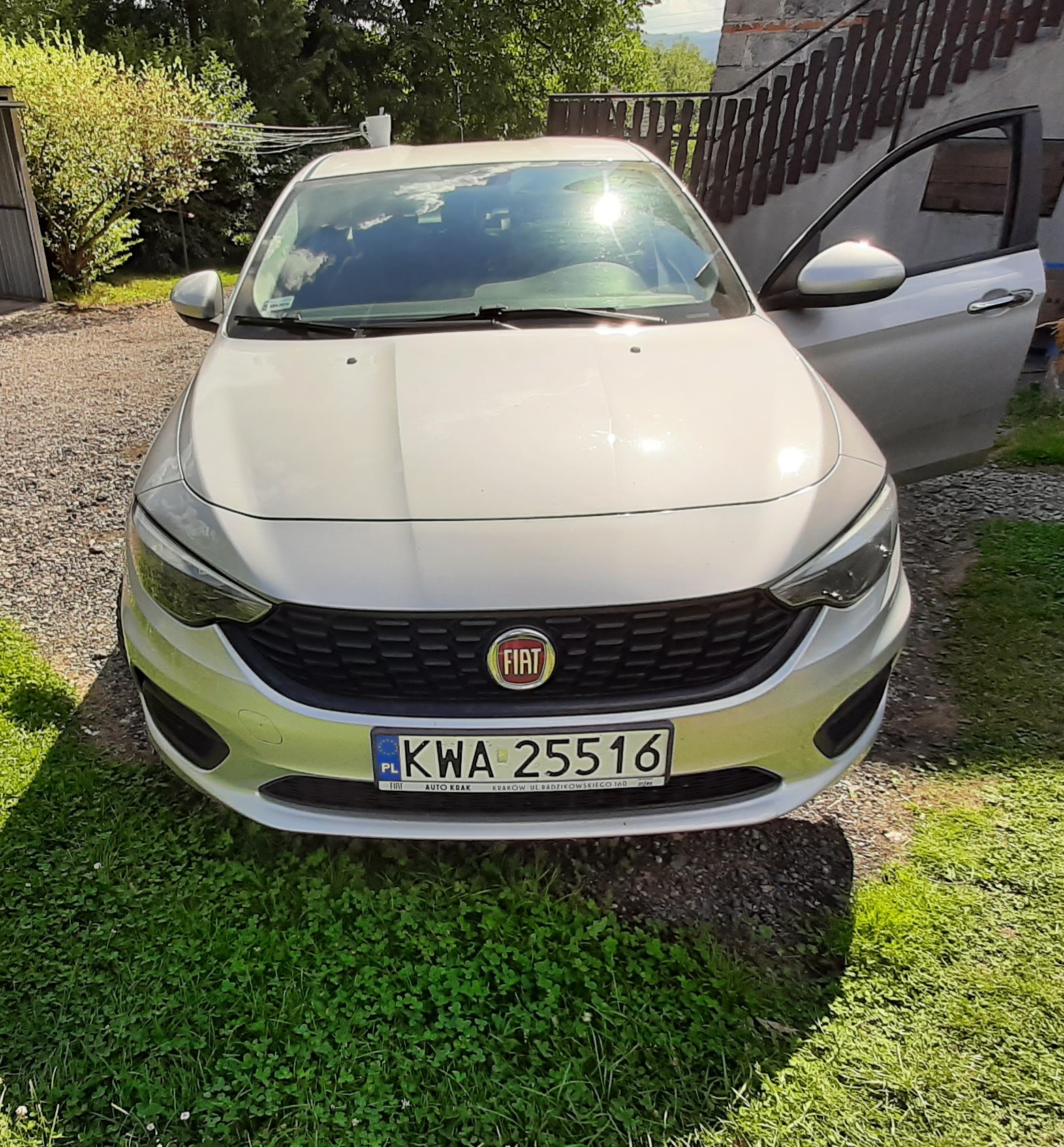 Srebrny FIAT TIPO widoczny od przodu z przednimi reflektorami, czarną osłoną chłodnicy oraz grillem z logo Fiata.