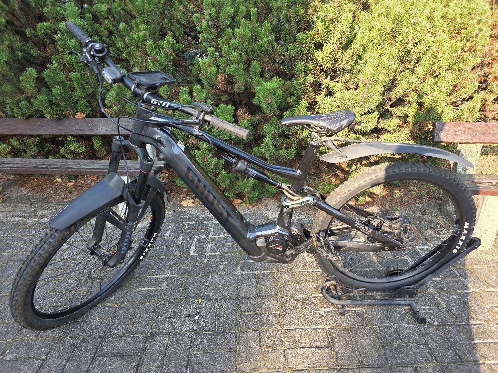 Rower elektryczny marki GHOST E-ASX 160 Universal wraz z podpórką na rower koloru czarnego