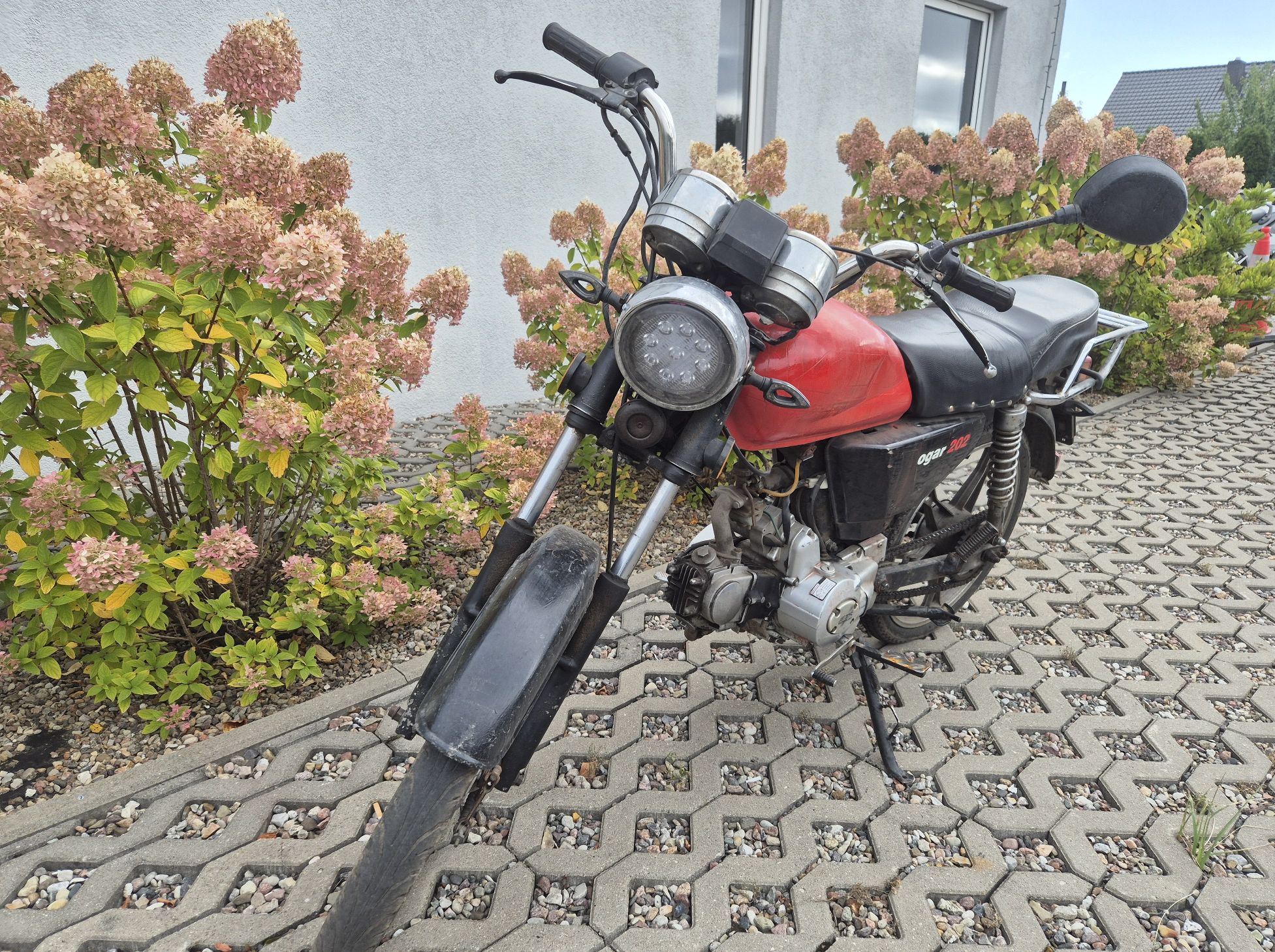 Widok motoroweru z przodu. Widoczne zużycie i zabrudzenia oraz nalot rdzy na metalowych elementach
