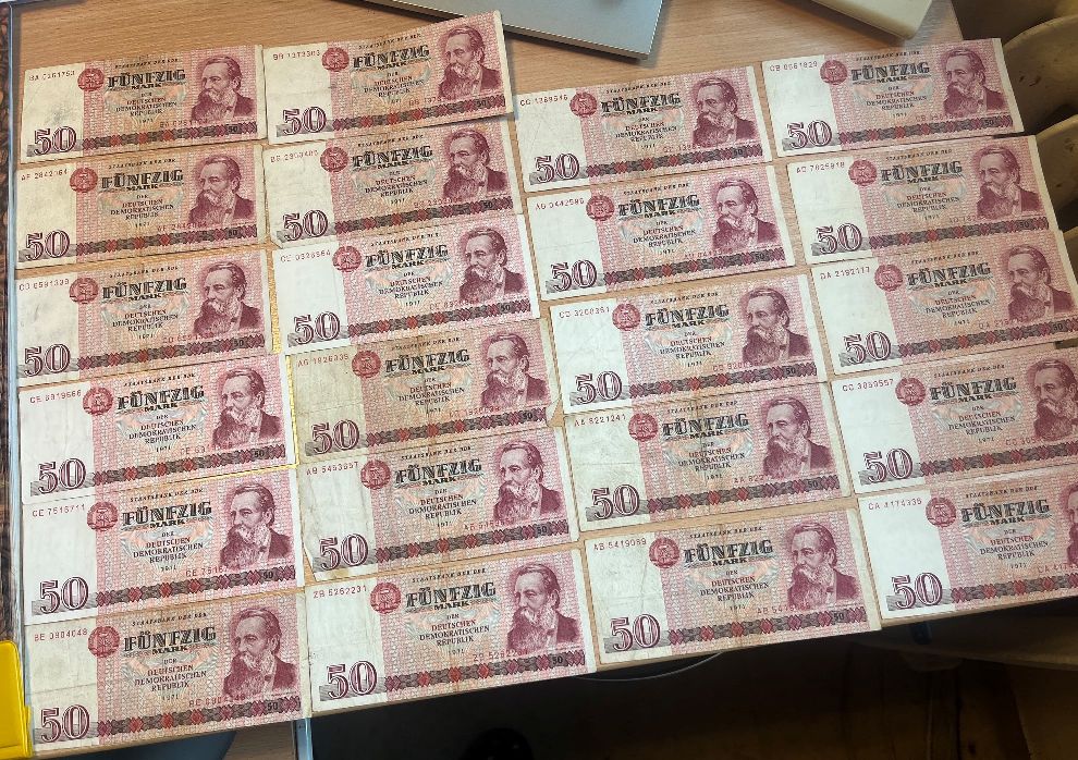 Zestaw banknotów o nominale 50 marek NRD z 1971 roku ułożonych w czterech pionowych kolumnach.
