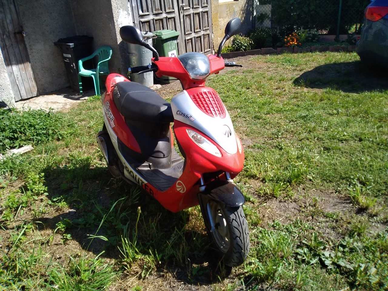 Czerwono-czarny motorower Romet, ujęcie z przodu, widoczny reflektor, kierunkowskazy i lusterka.