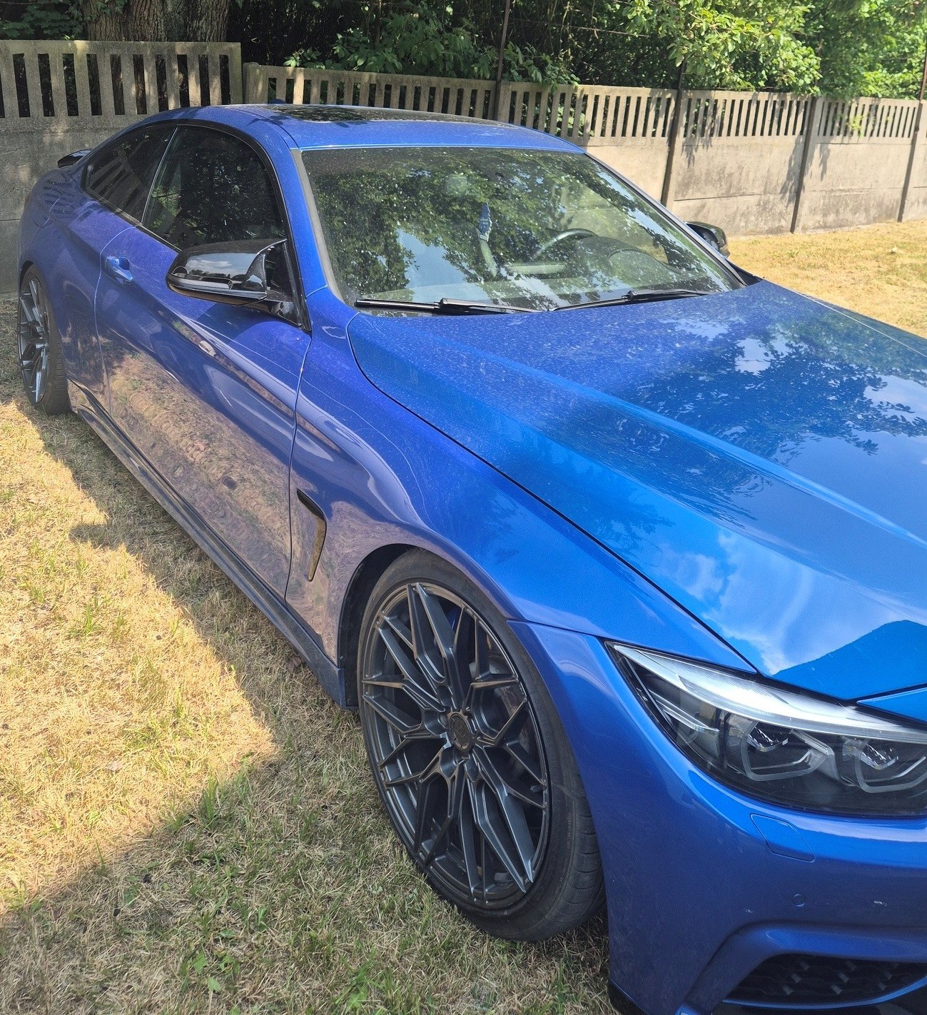 Niebieskie BMW z polską tablicą rejestracyjną, zdjęcie prawy bok.