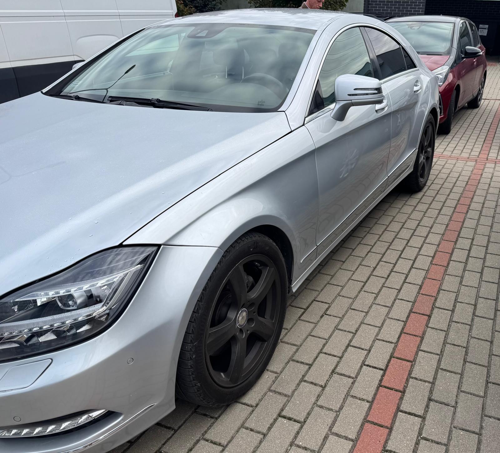 Srebrny Mercedes-Benz CLS z widocznym lewym bokiem.