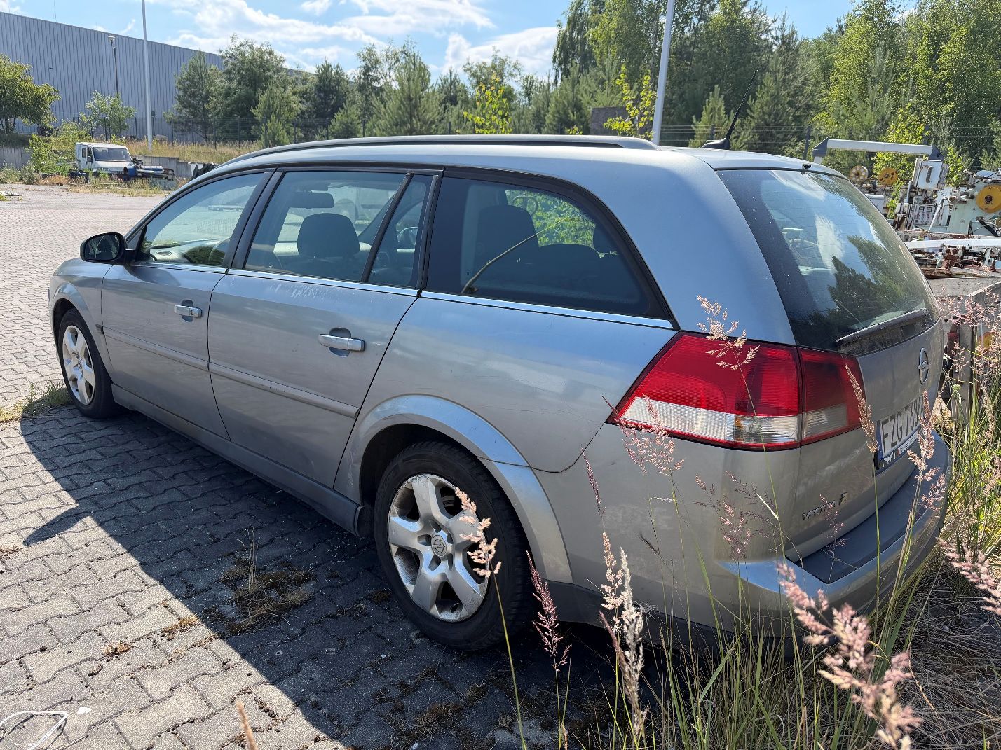 Szary Opel Vectra. Ujęcie lewego tyłu.