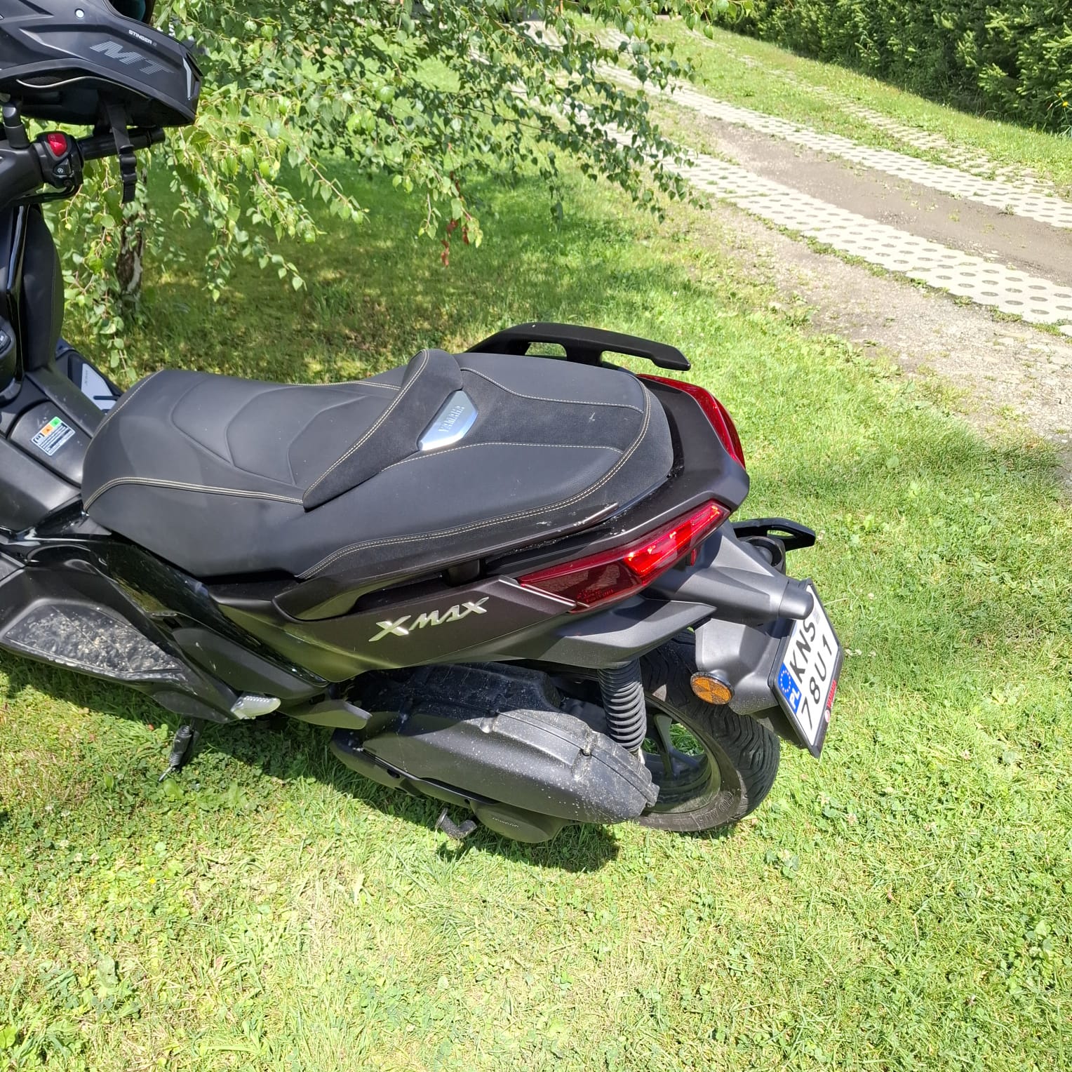 Lewy bok czarnego skutera Yamaha.