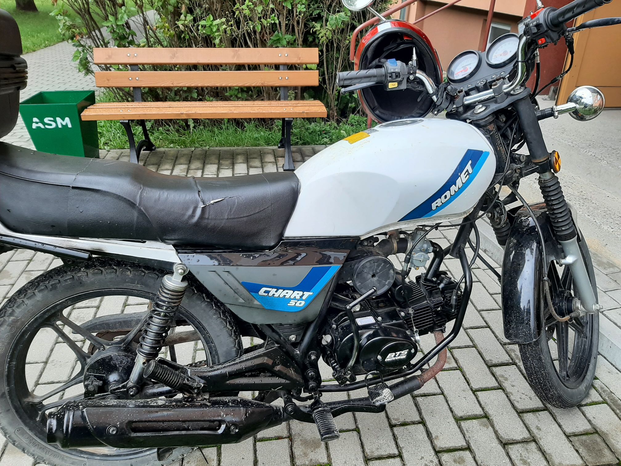 Motorower Romet Chart 50 z dwoma lusterkami, okrągłym zegarem i przednim reflektorem.
