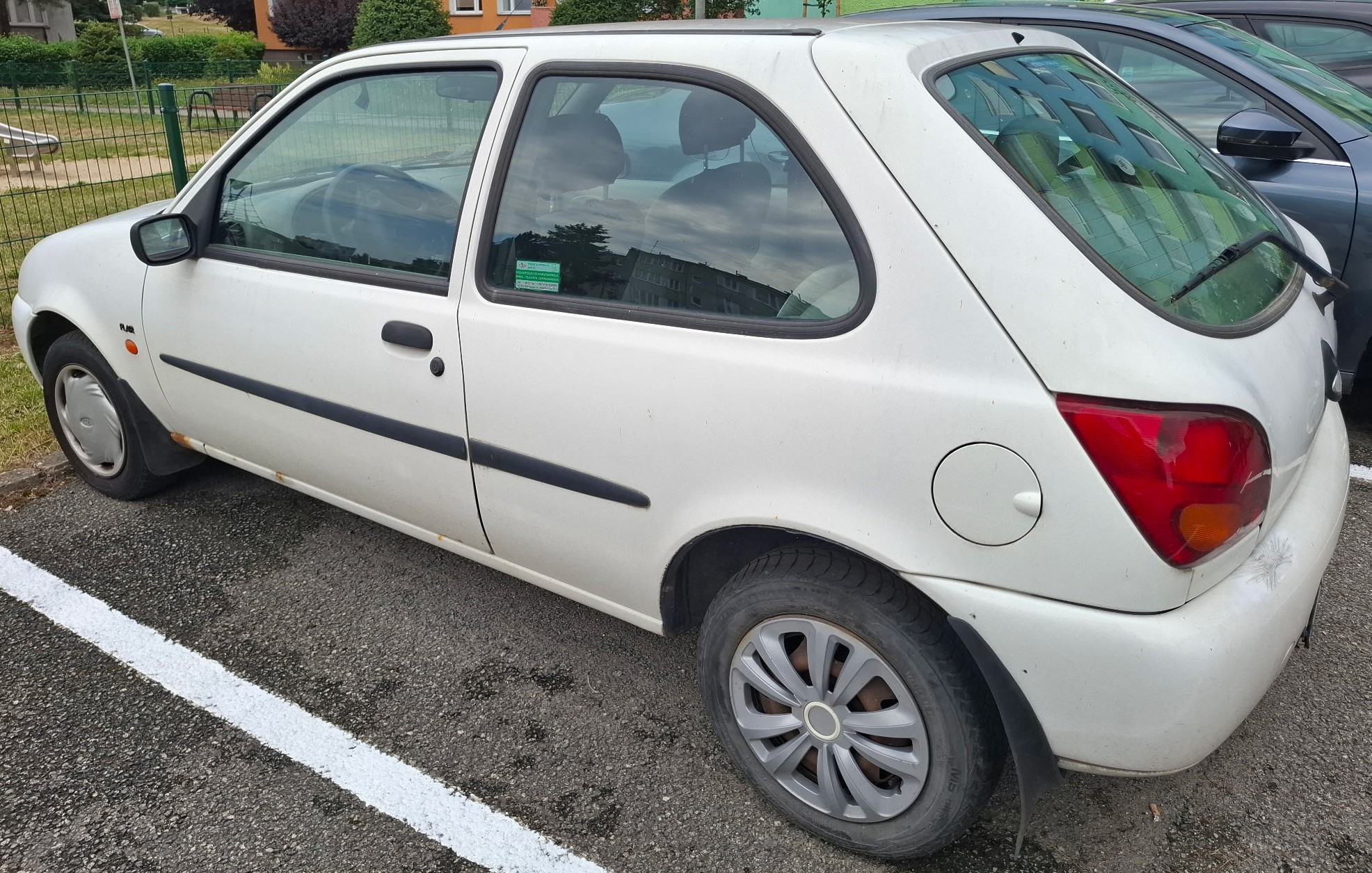Biały Ford Fiesta, widok z lewego boku i tyłu.