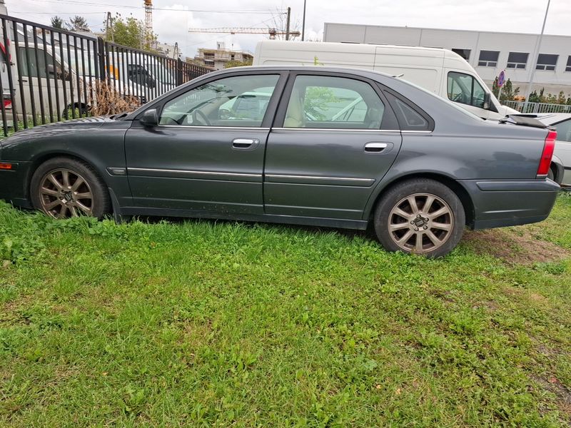 Samochód osobowy koloru grafitowego VOLVO S80 widoczny z lewej strony.