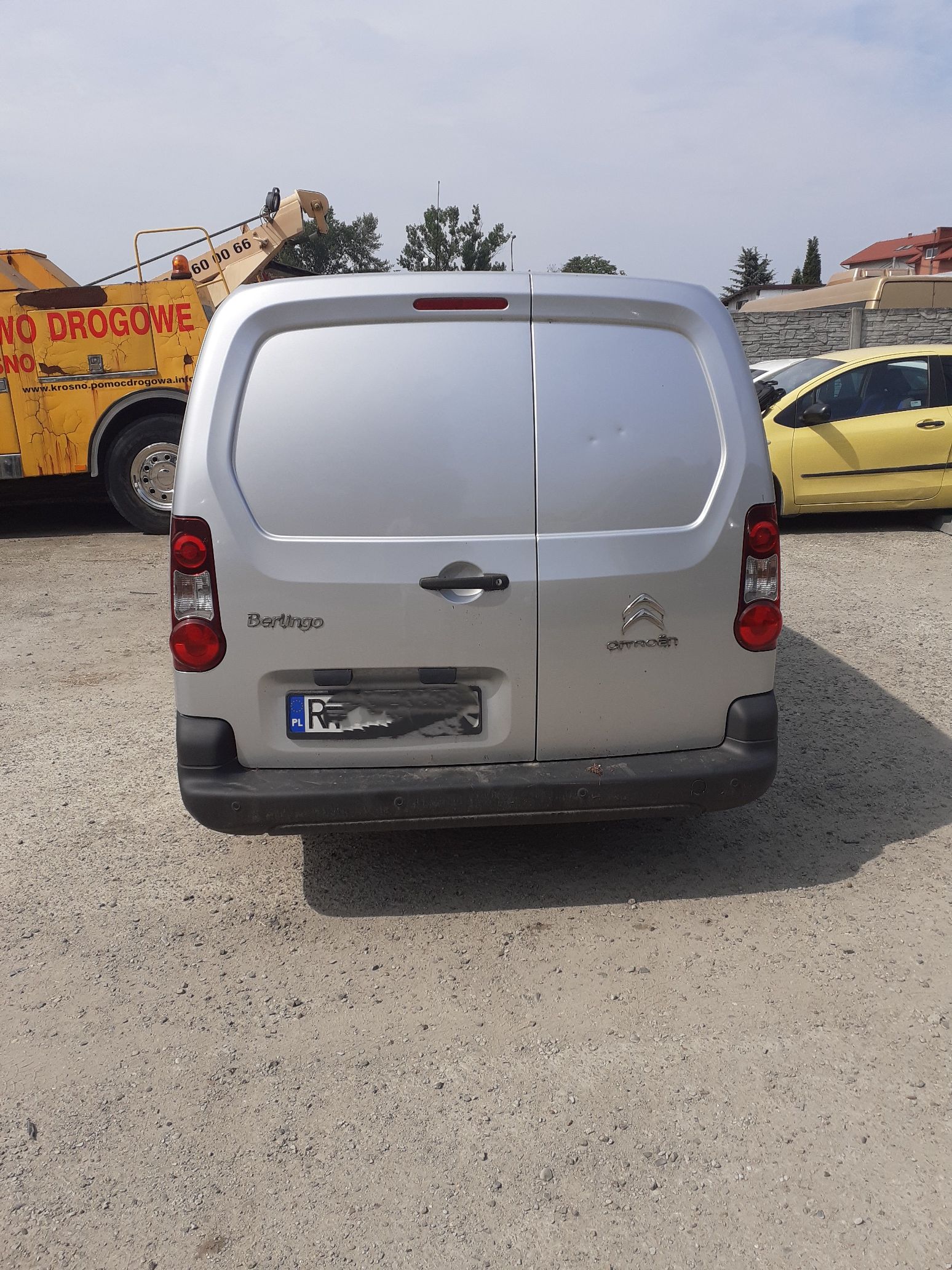 Tył srebrnego Citroëna Berlingo z logo marki i napisem modelu. Widoczne dwuskrzydłowe drzwi i czarny zderzak.