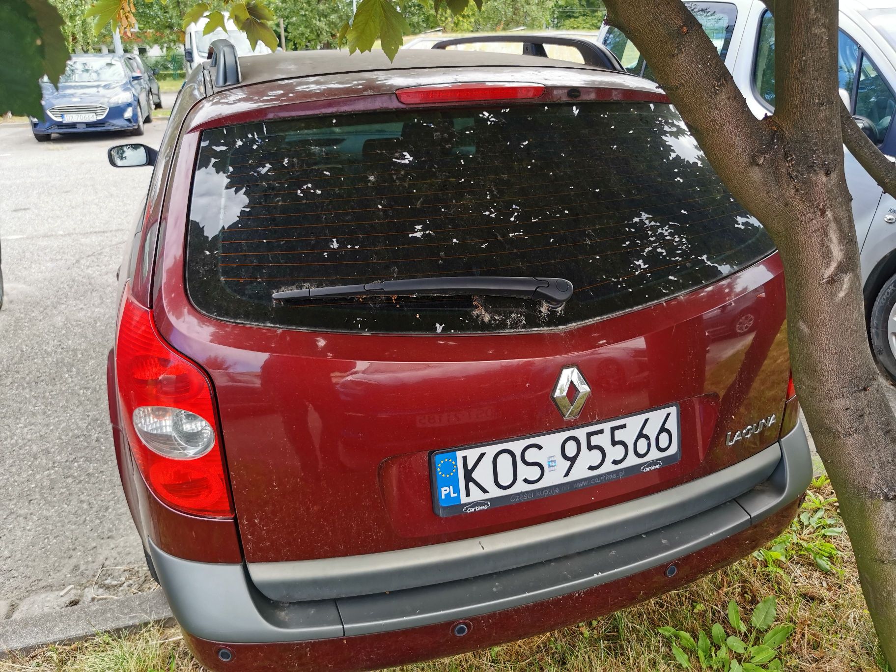 Samochód osobowy marki Renault Laguna kombi rocznik 2004 , kolor bordowy, widok z tyłu.