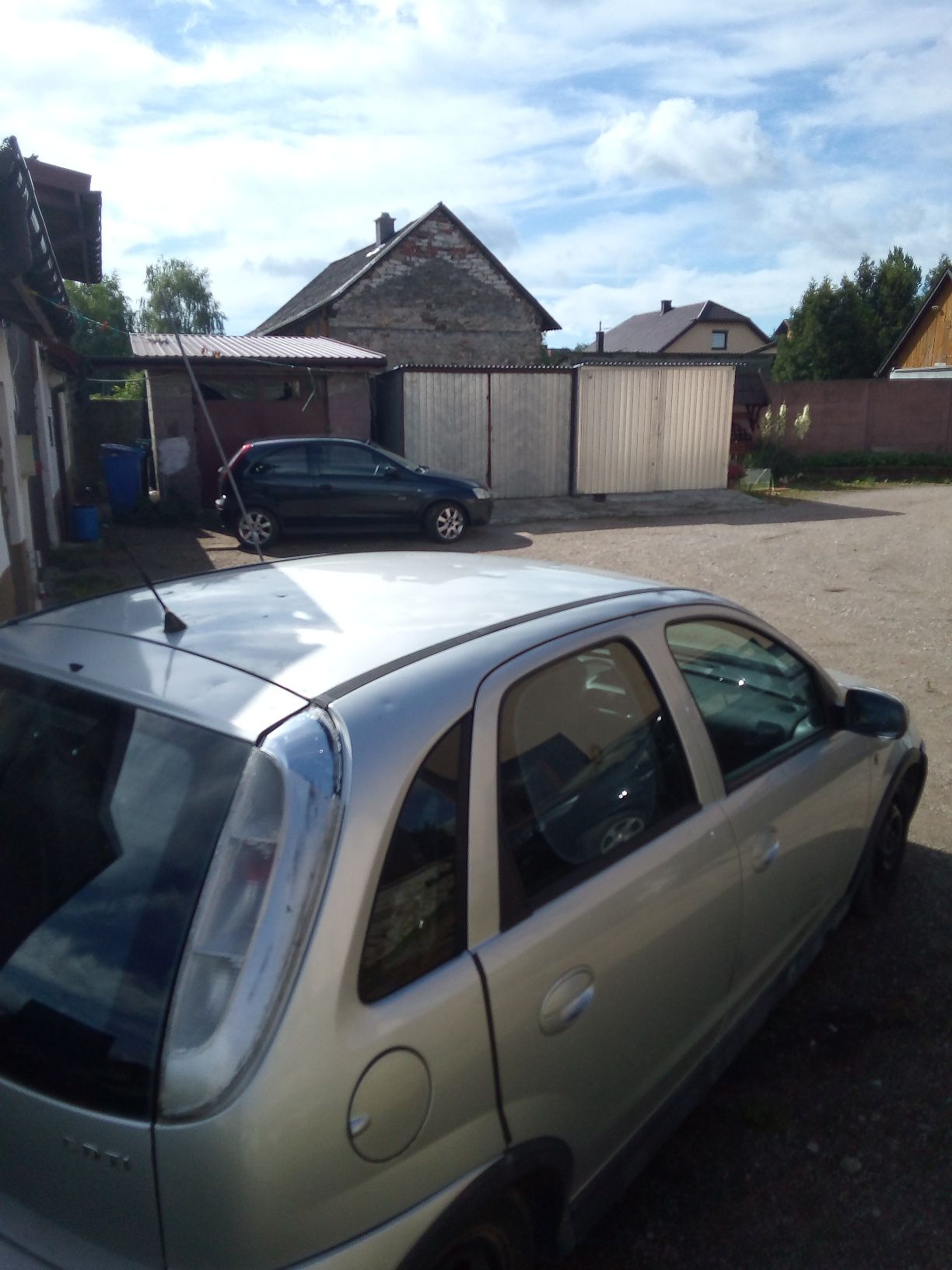 Srebrny samochód osobowy marki Opel Corsa widziany z boku, na karoserii widoczne wgniecenia po gradobiciu