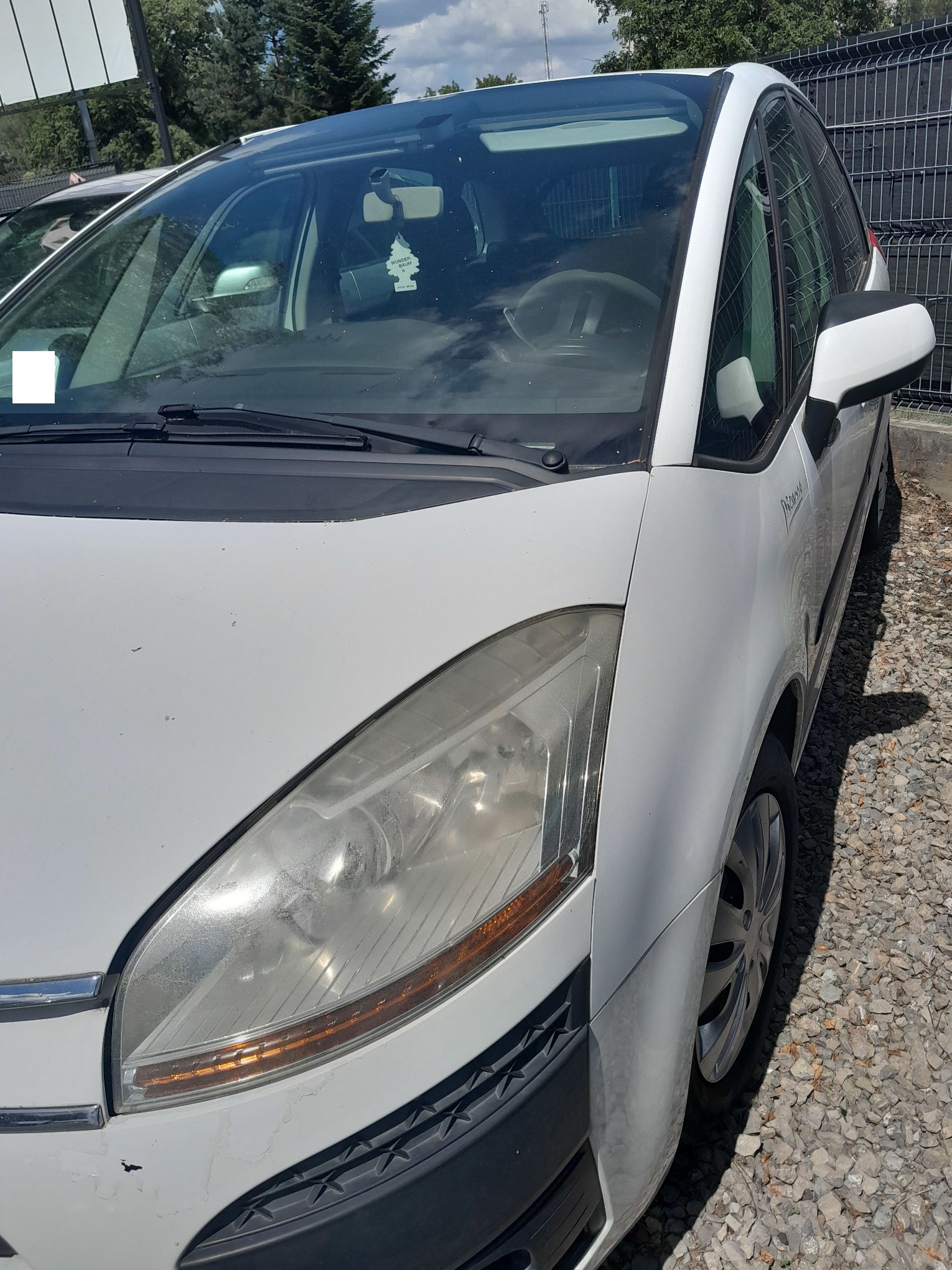 Biały Citroen C4, ujęcie lewej strony pojazdu