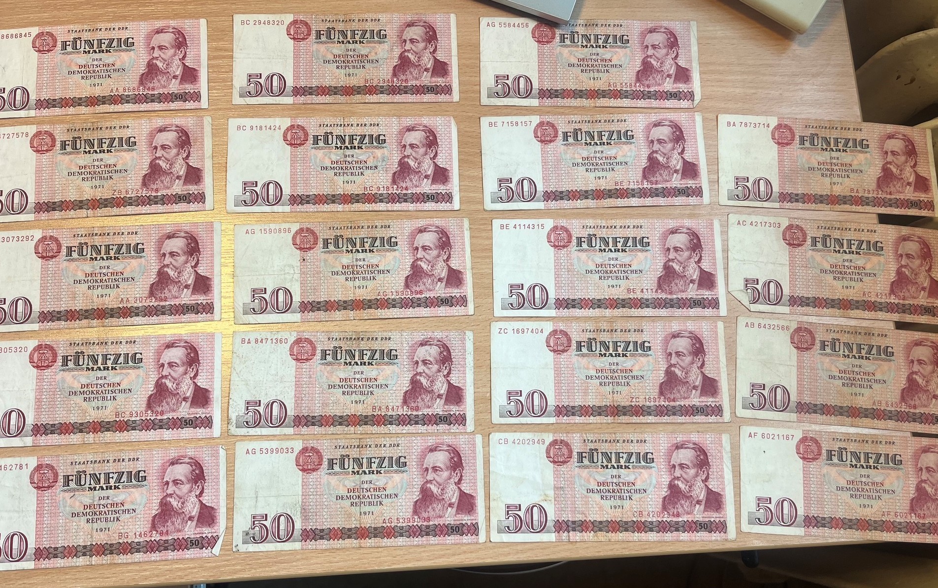 Zestaw banknotów o nominale 50 marek NRD z 1971 roku ułożonych w pięciu rzędach.