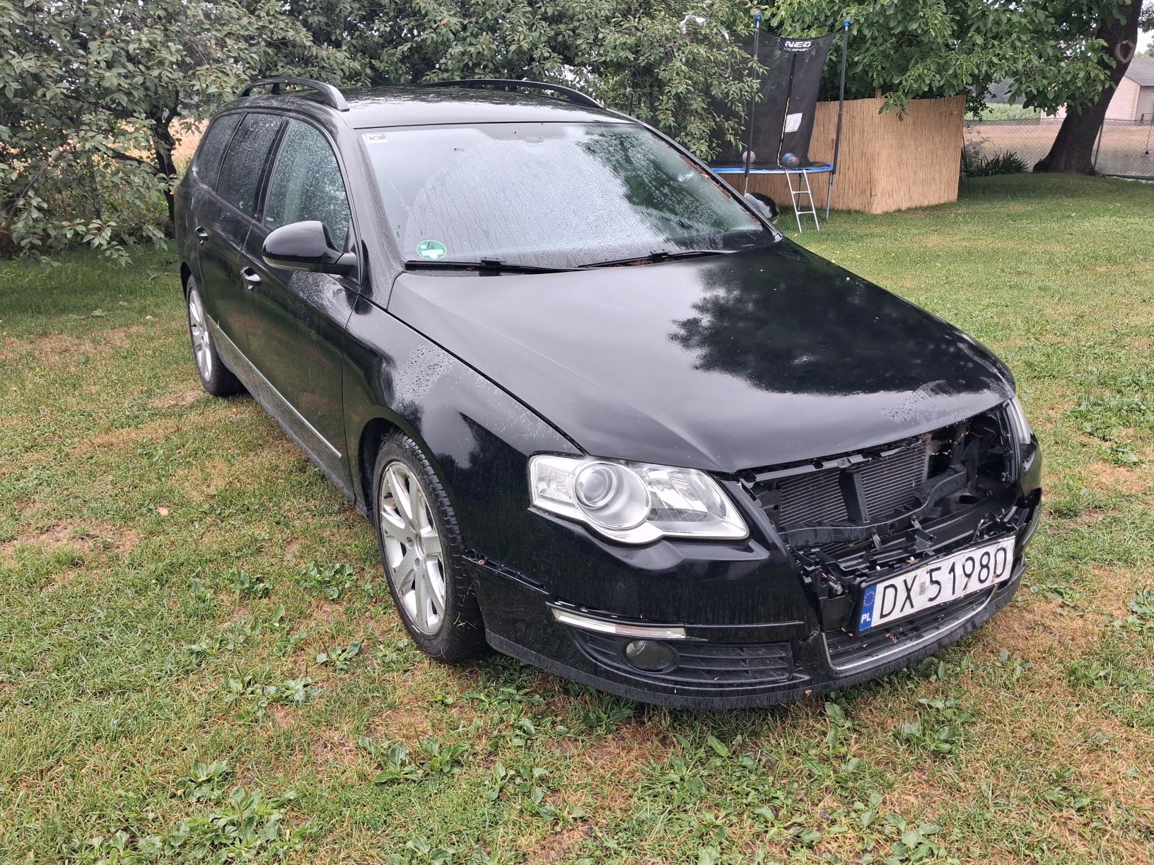 Przód czarnego samochodu z widocznym uszkodzeniem.