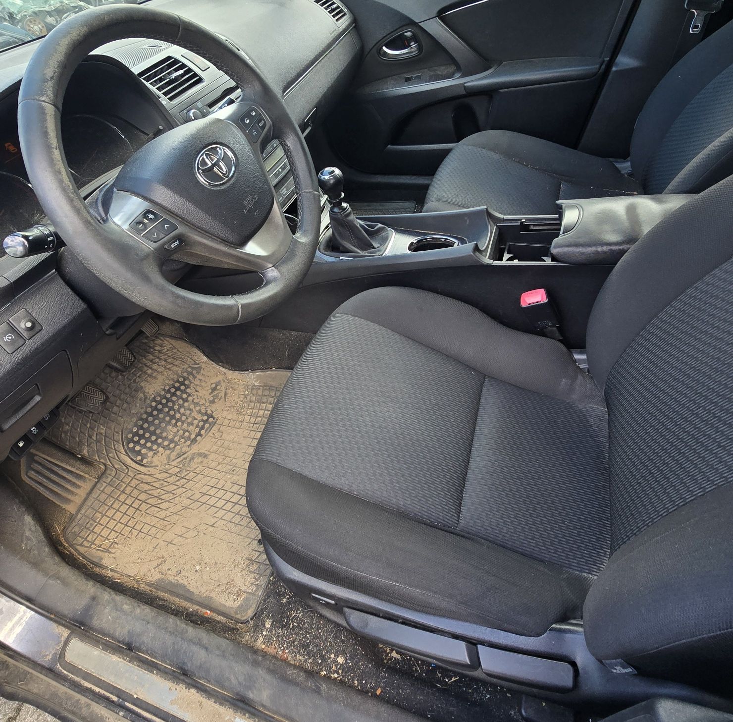 Wnętrze Toyoty Avensis z widocznymi uszkodzeniami i zabrudzeniami tapicerki