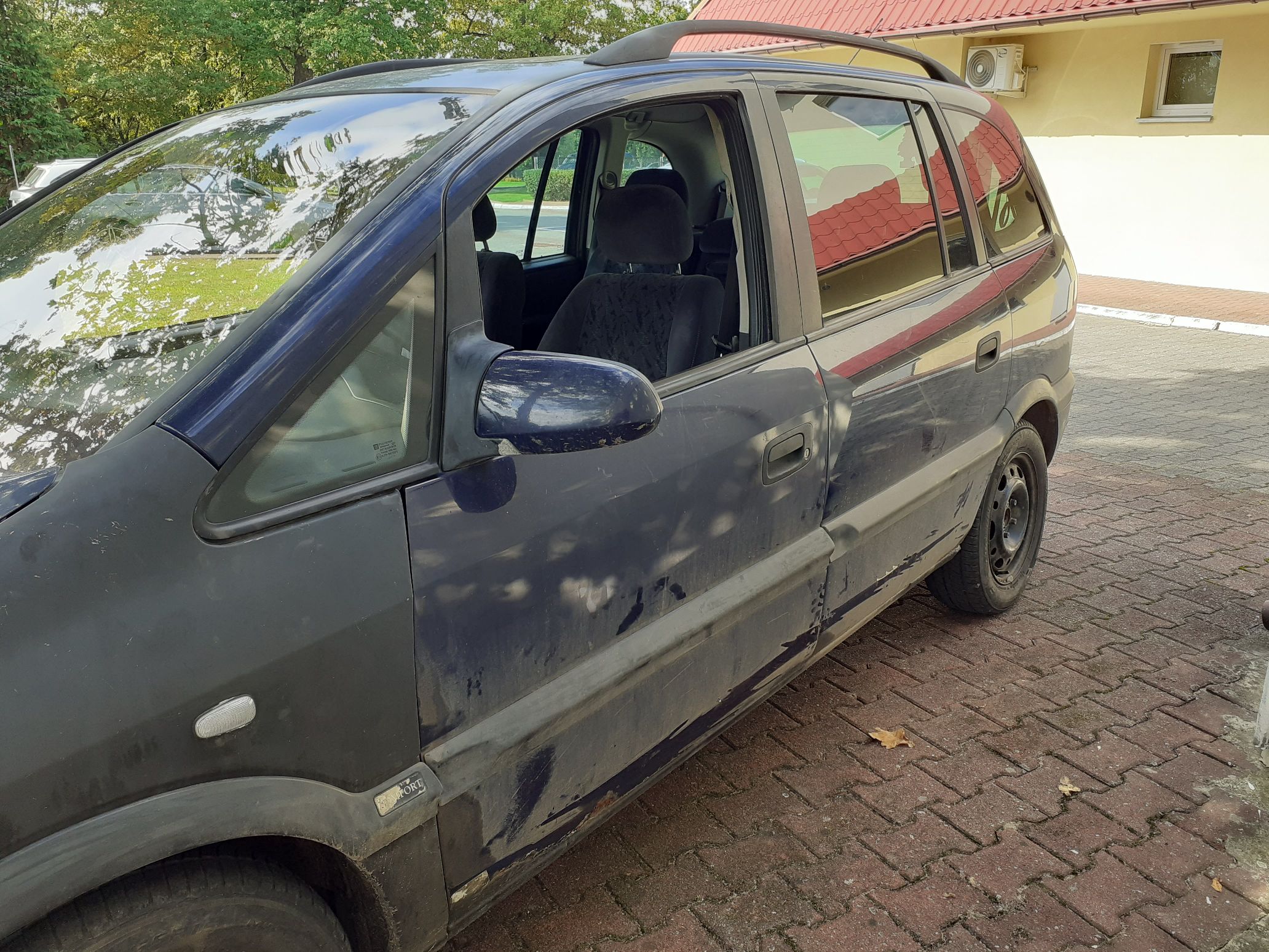 Lewy bok granatowego samochodu marki Opel Zafira.