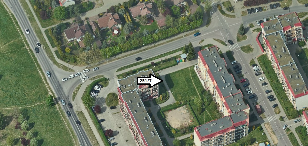 widoczne z góry bloki mieszkalne z parkingami i wewnętrznym dziedzińcem