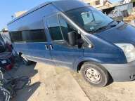 Bok i przód niebieskiego vana Ford Transit z przyciemnianą podłużną szybą boczną