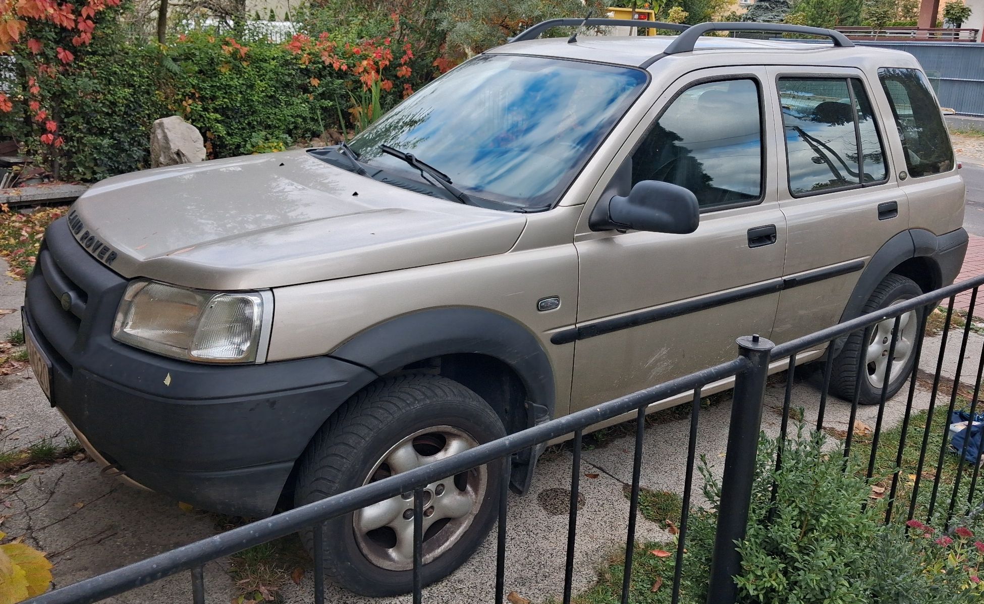 Samochód osobowy koloru beżowego. Widok na lewy bok