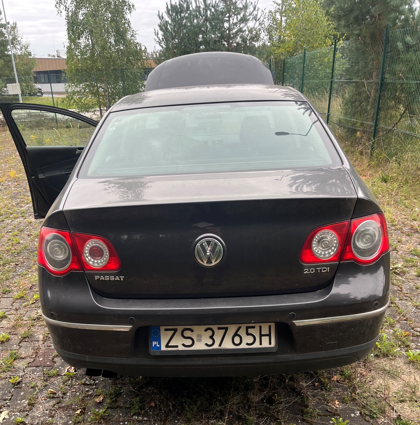 Tył samochodu Volkswagen Passat z otwartymi drzwiami kierowcy oraz uniesioną maską z przodu.